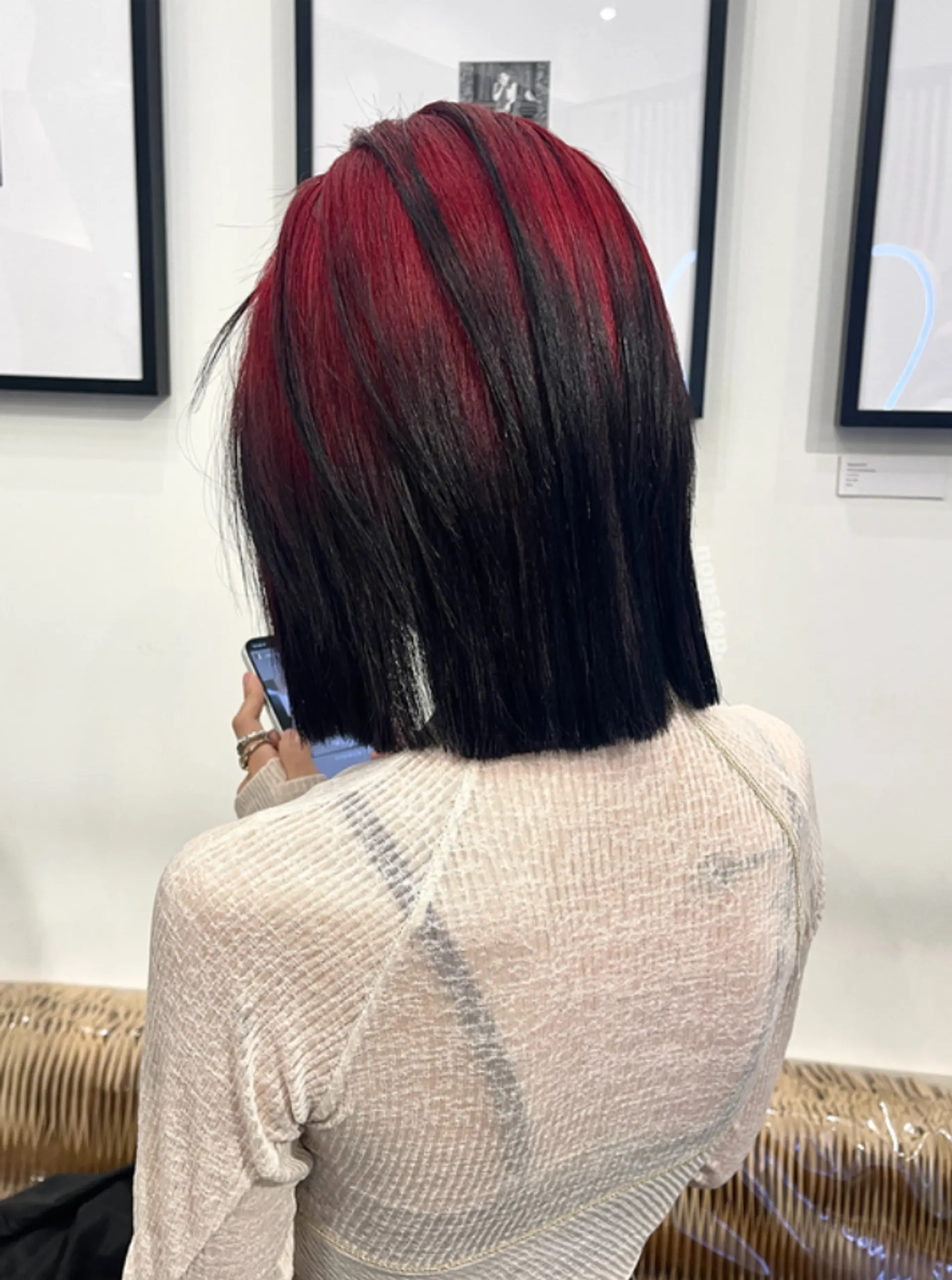A medium-length straight bob with vibrant crimson red hues on the top layers, transitioning into deep black on the lower layers, cut with precise, edgy layers for a bold, modern look. 2