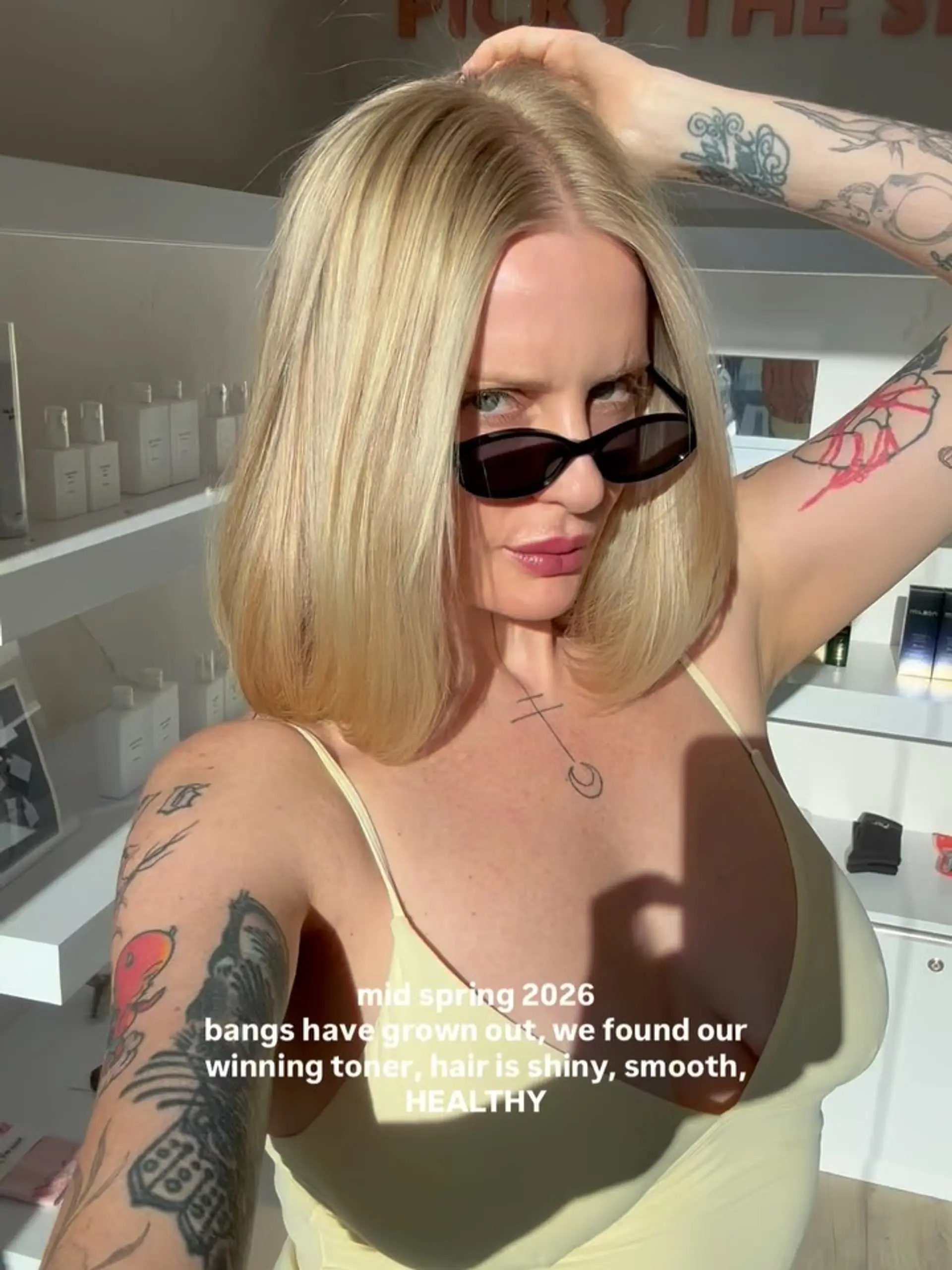 A polished shoulder-length blonde lob styled with a smooth blowout and soft inward-curving ends. 1