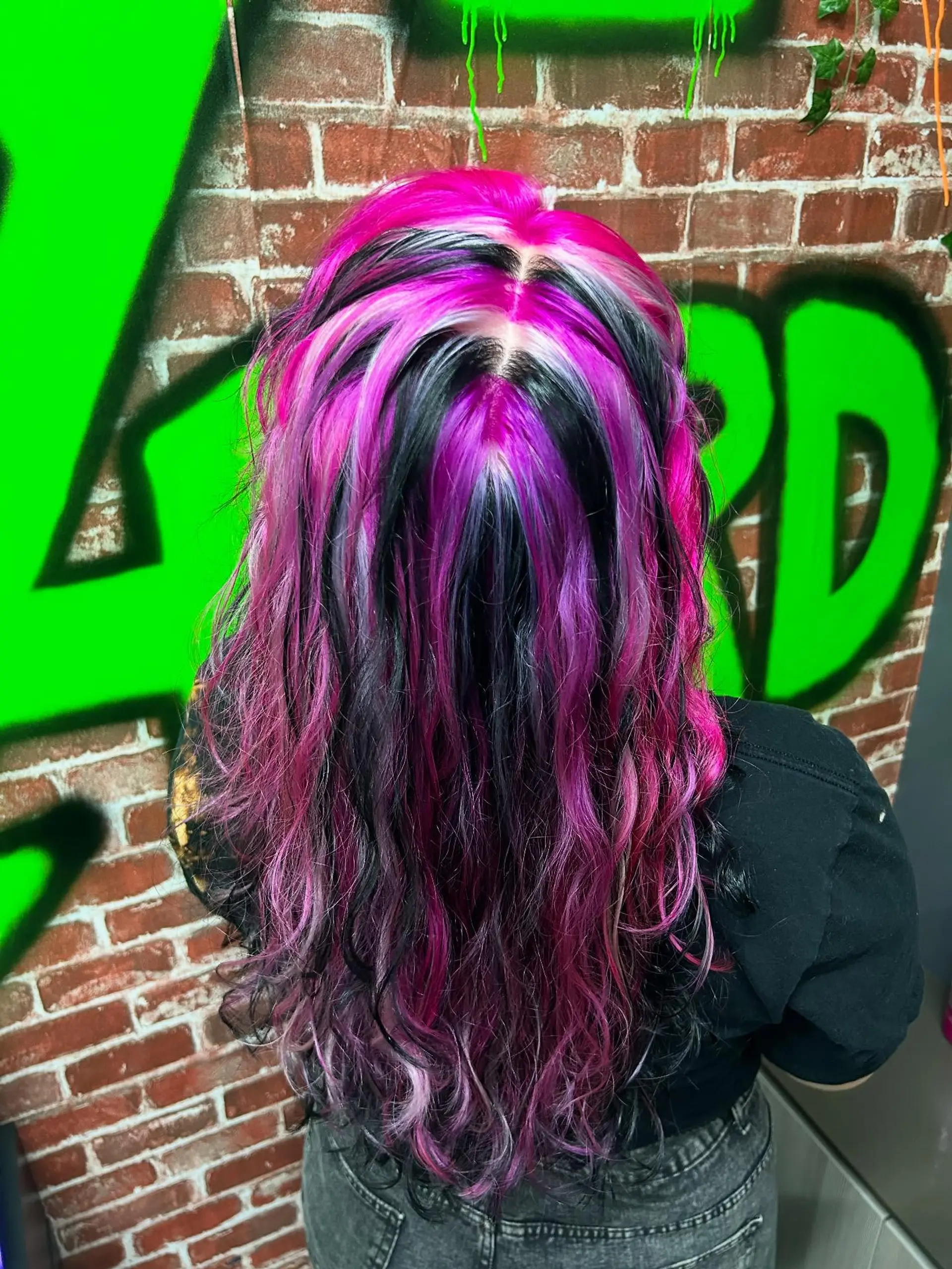 Long wavy hair styled with dramatic, high-contrast chunky highlights in hot pink, black, and platinum white. 1