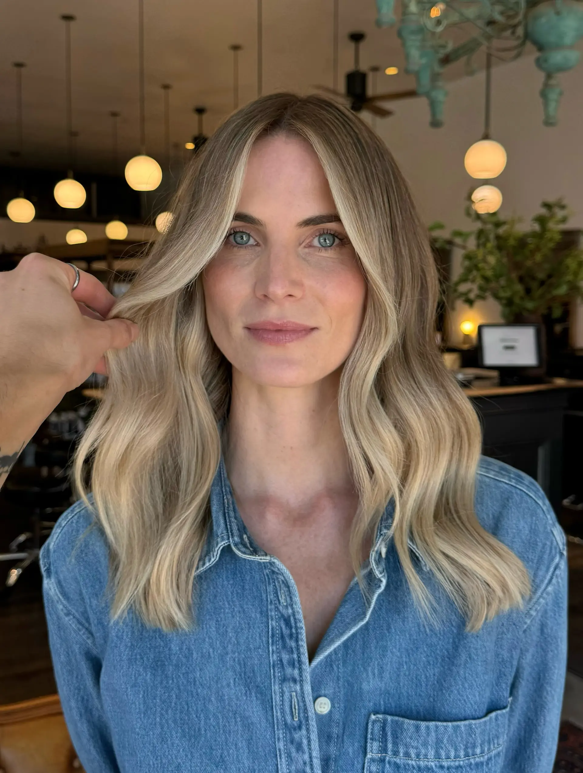 Medium-to-long ash blonde hair styled in soft, loose waves with bright face-framing highlights and a center part. 1