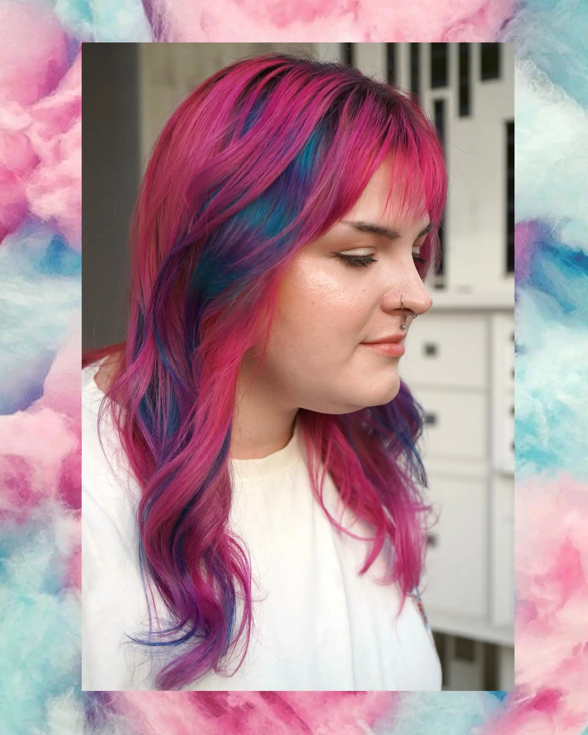 Vibrant pink hair featuring blue and purple peekaboo highlights, wispy bangs, and soft layered waves. 1