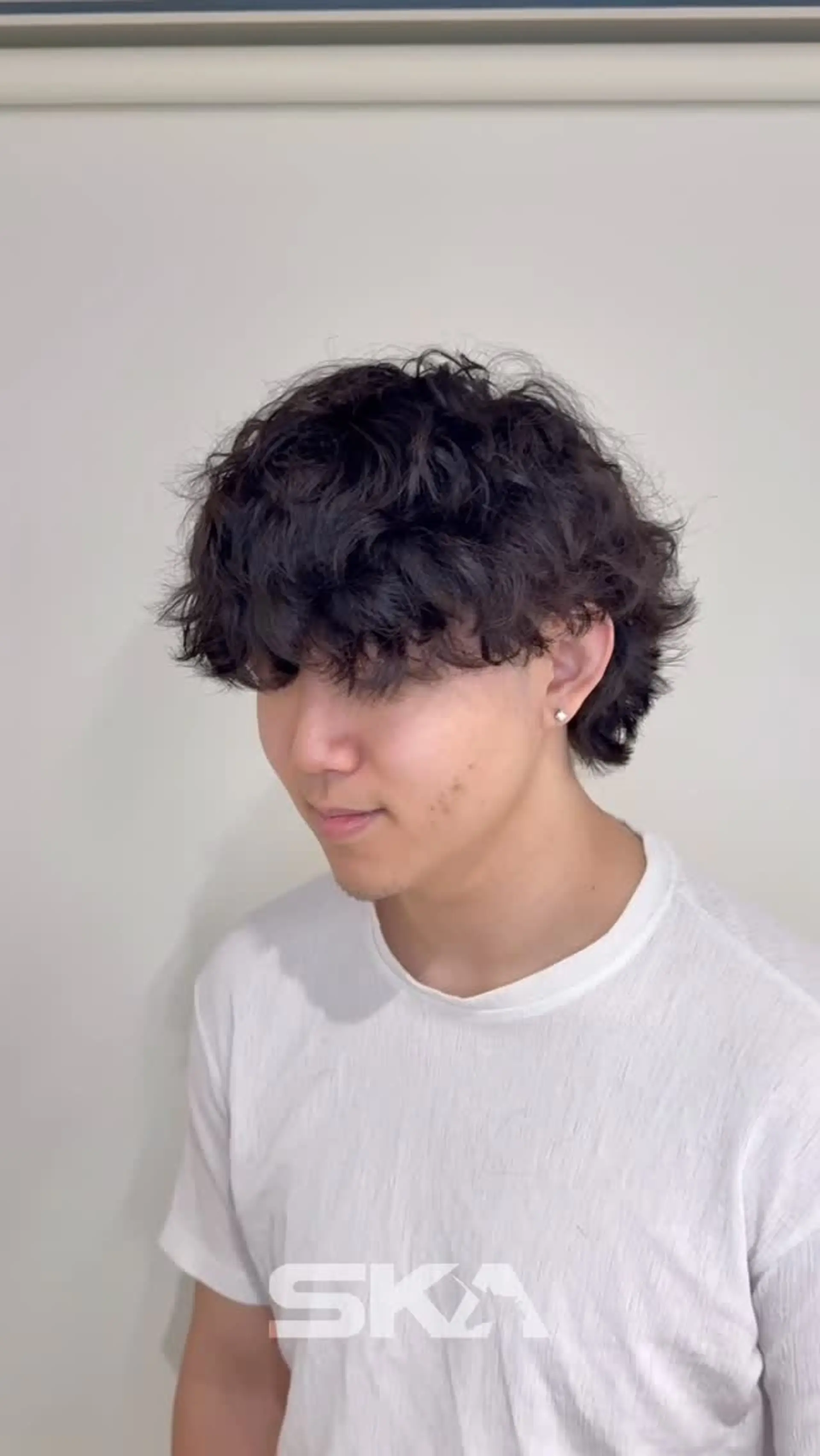 A short, tousled hairstyle enhanced with loose waves, offering natural volume and textured fringe falling across the forehead. 1