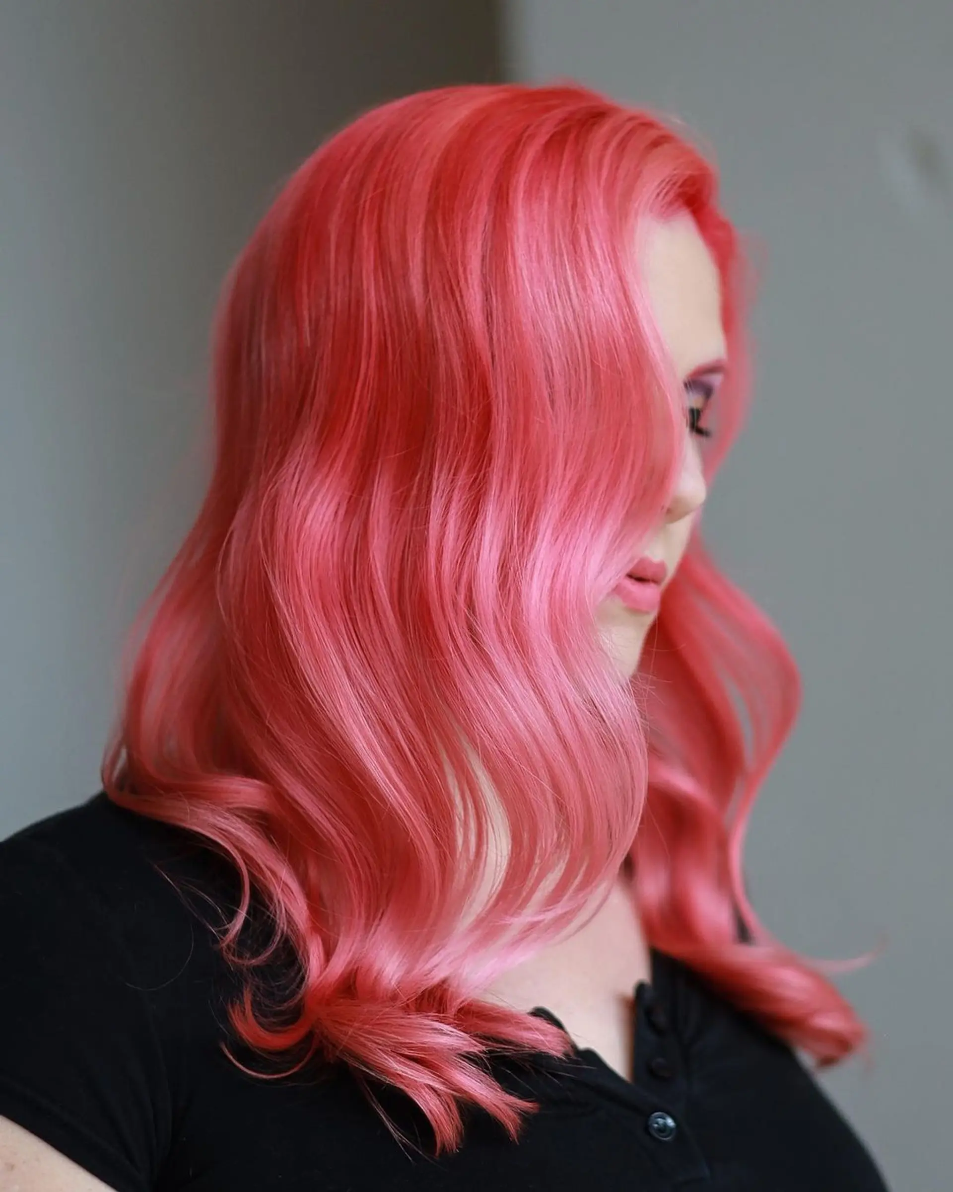 Wavy, pastel pink medium-length hair with a side part and loose waves. 1