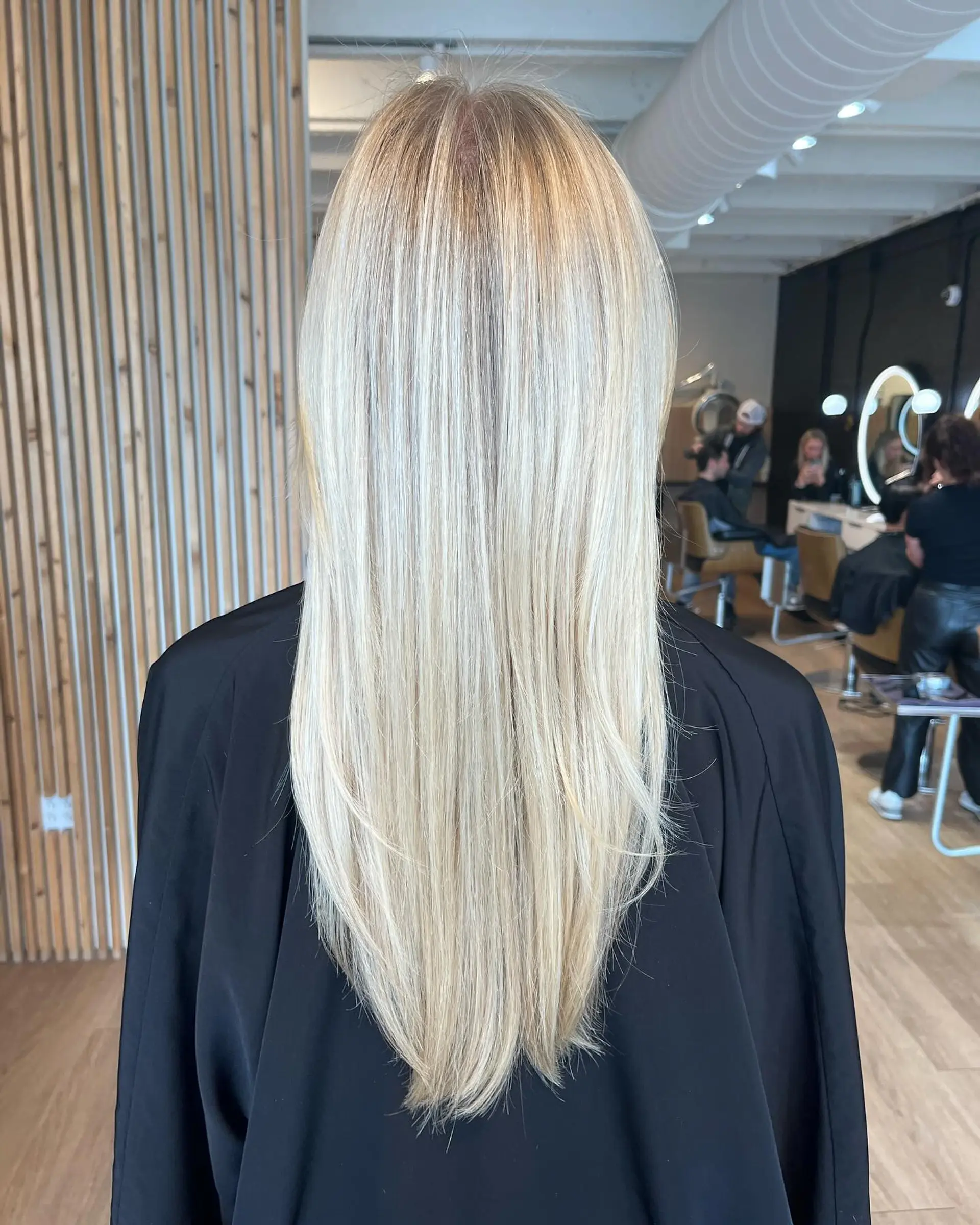 Long, sleek straight blonde hair styled smooth with fine, luminous highlights and a subtle V-cut shape at the ends. 1