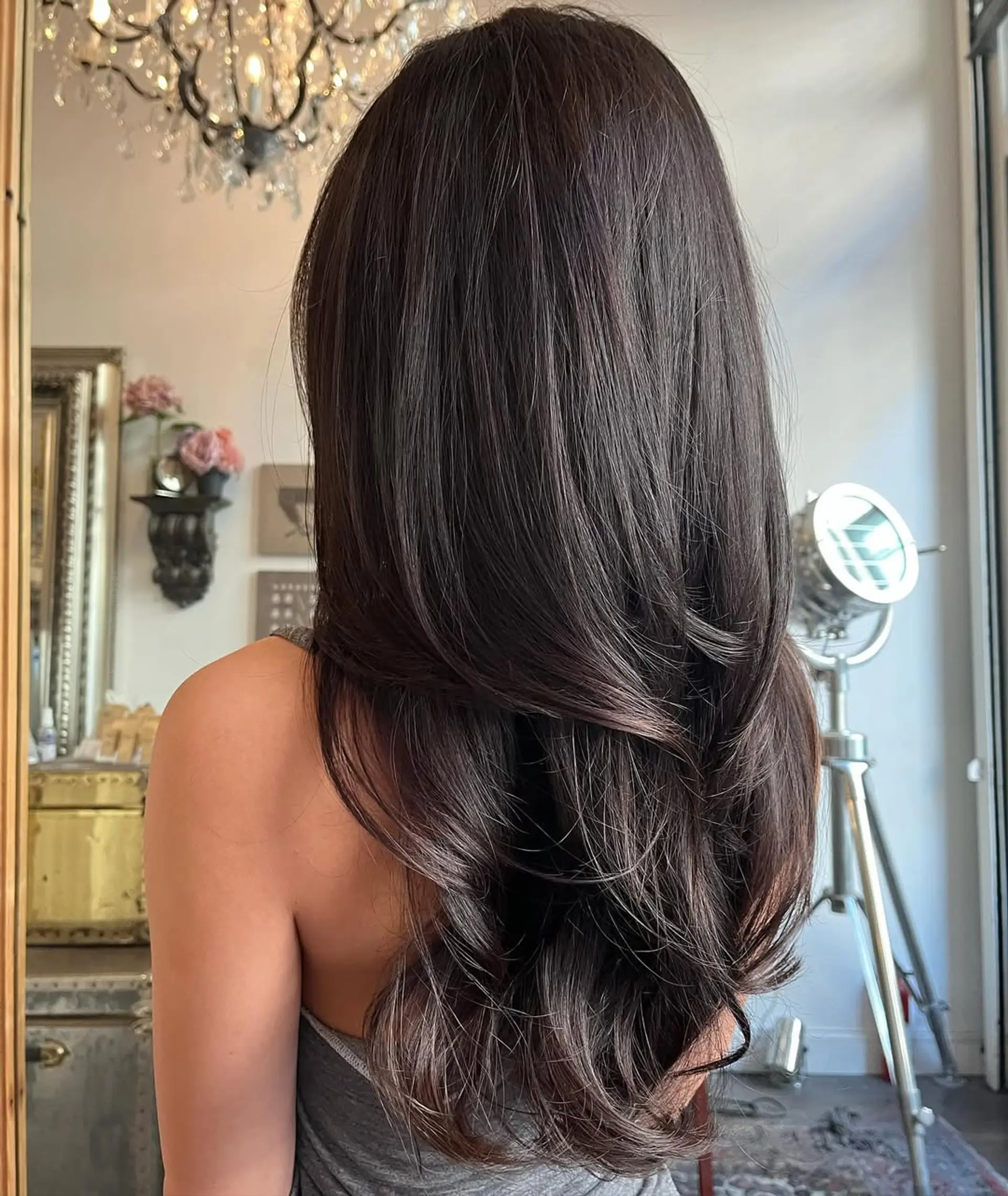 Long dark brown hair with soft waves and subtle layered ends creating a luxurious and elegant look. 1