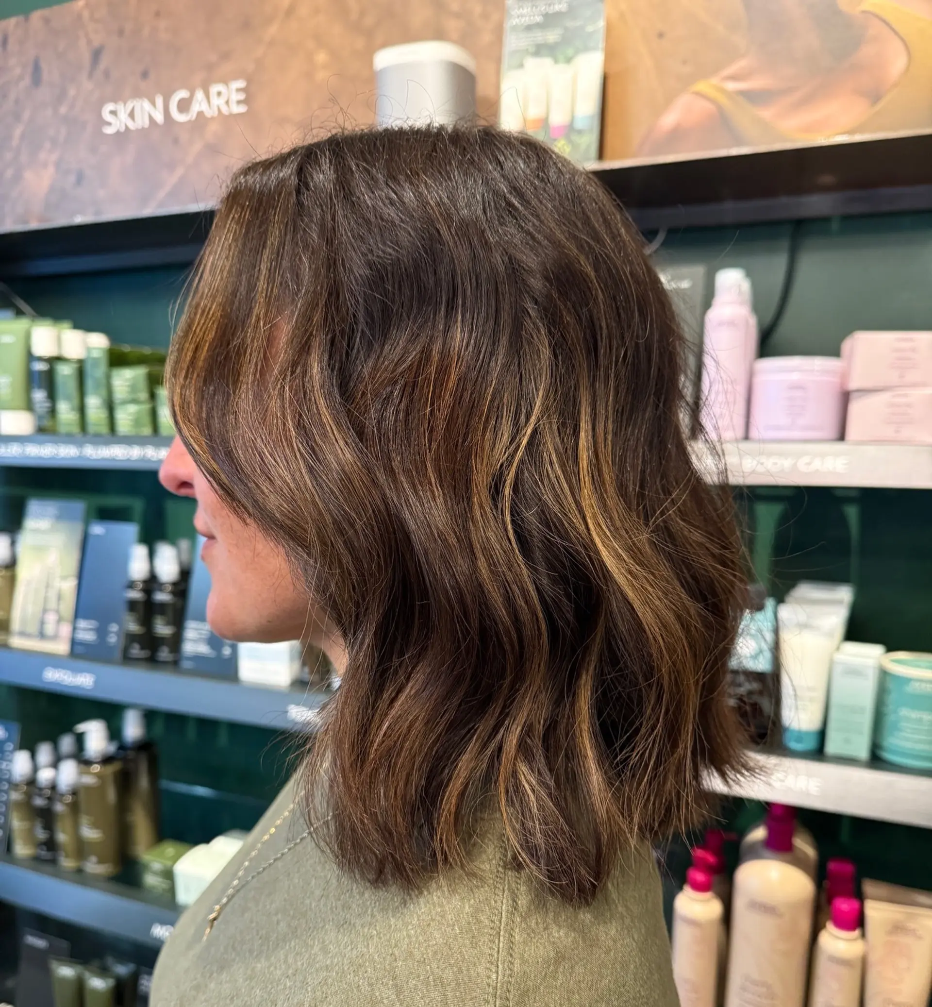 A shoulder-grazing wavy lob featuring rich teddy bear brown tones accented with honey highlights. 1