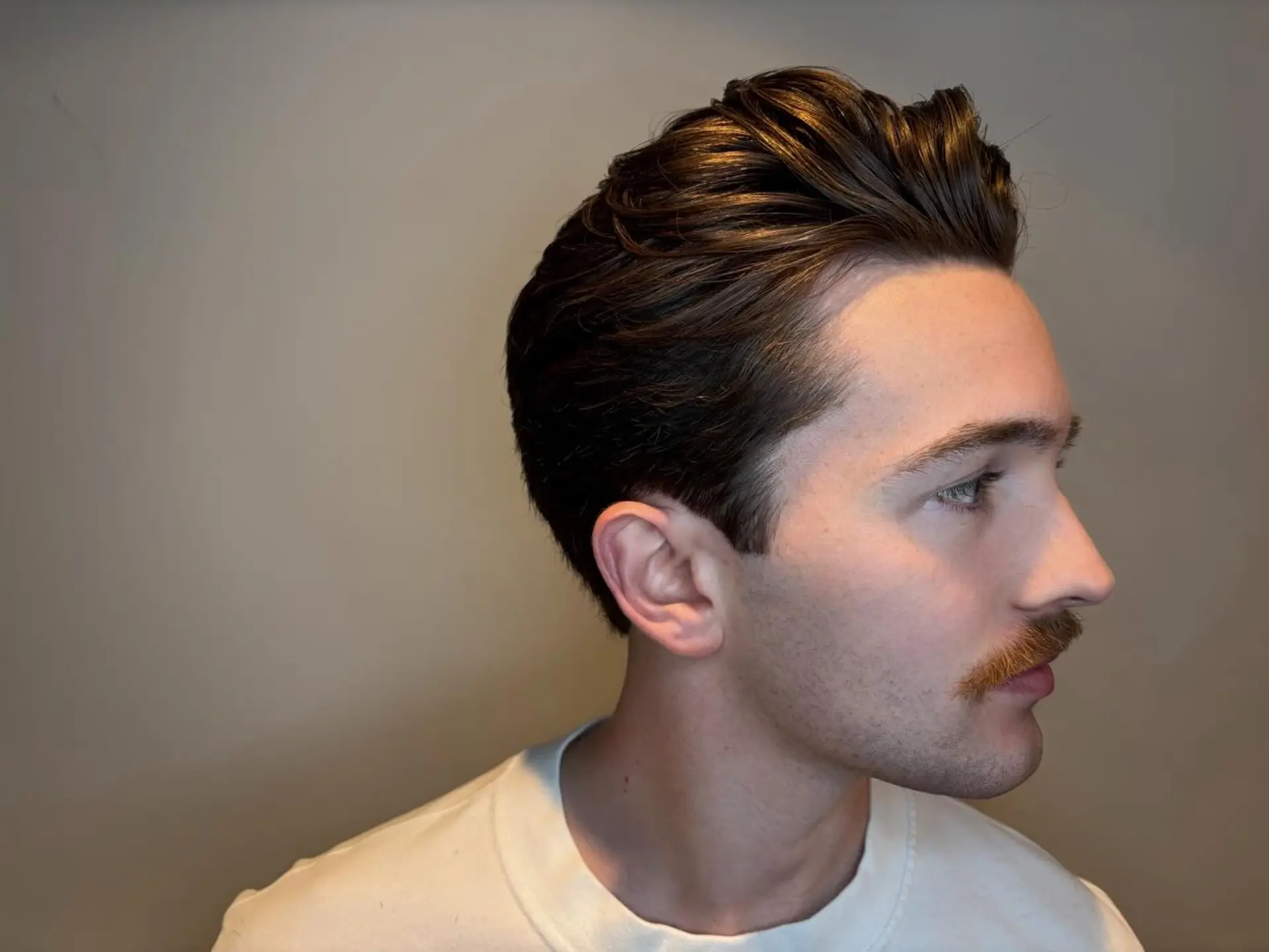 A classic men's haircut with scissor-tapered sides and a voluminous brushed-back top. 1