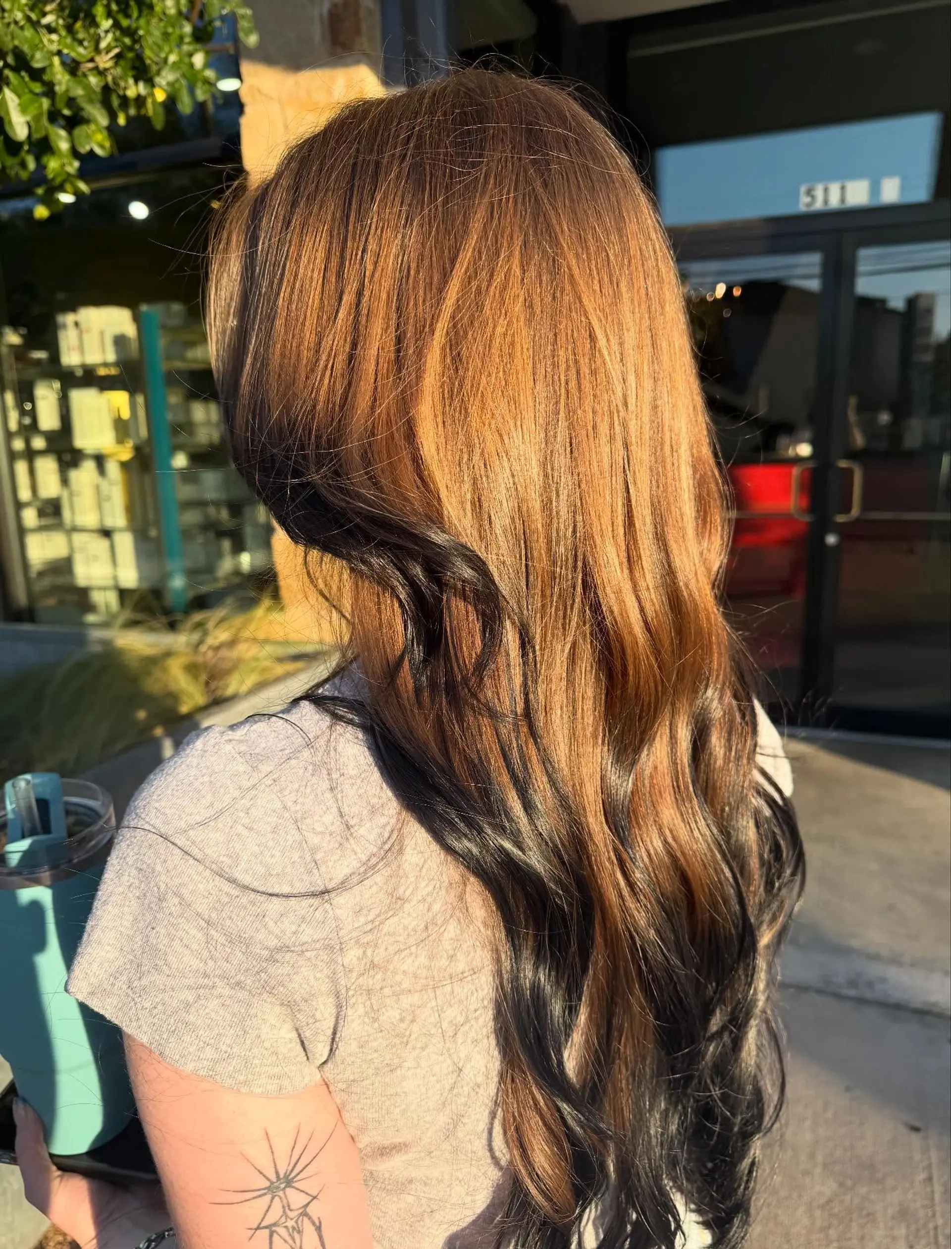 Long, flowing warm copper hair with a contrasting black peekaboo underlayer, styled in loose waves. 1