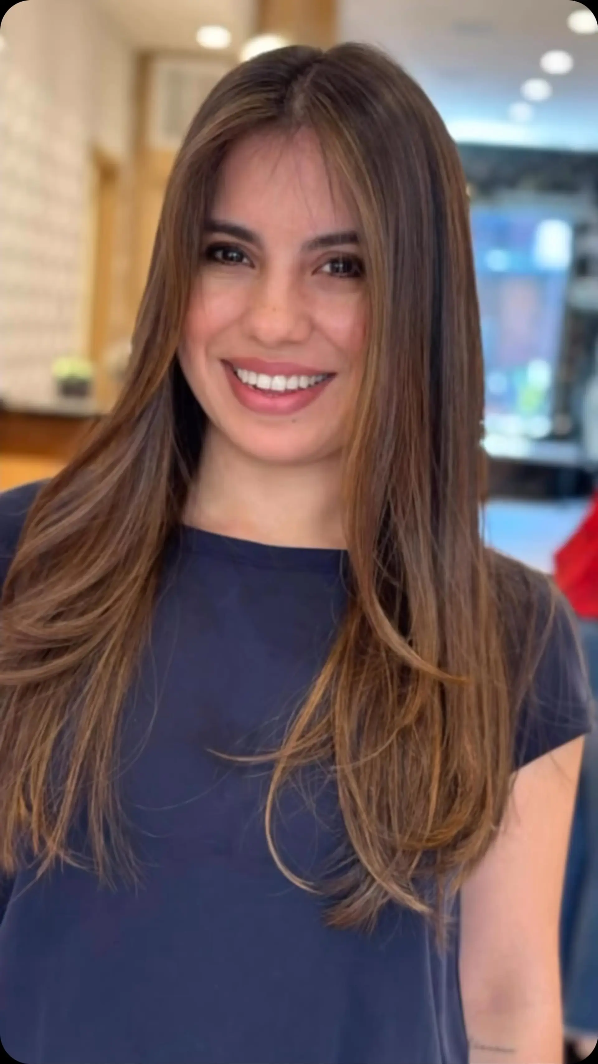 Long sleek brunette hair with subtle caramel balayage dimension and soft, face-framing layers. 1