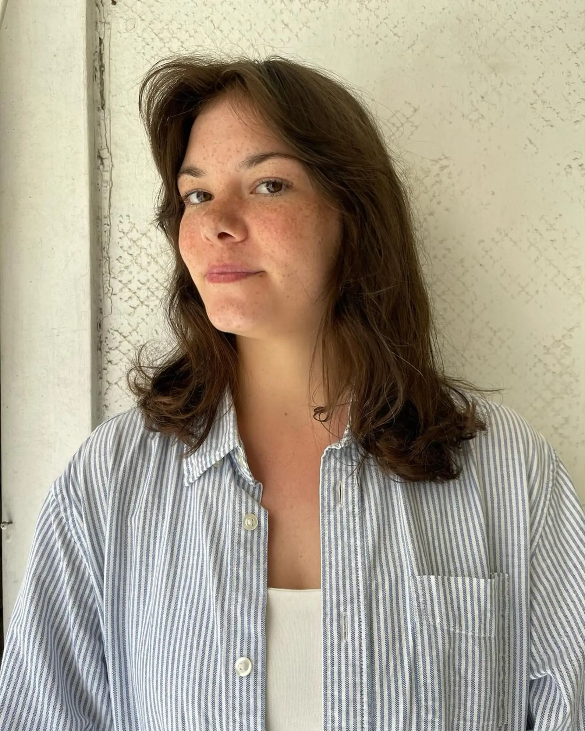 Medium-length wavy brown hair with soft layers, creating a natural, casual style. 1