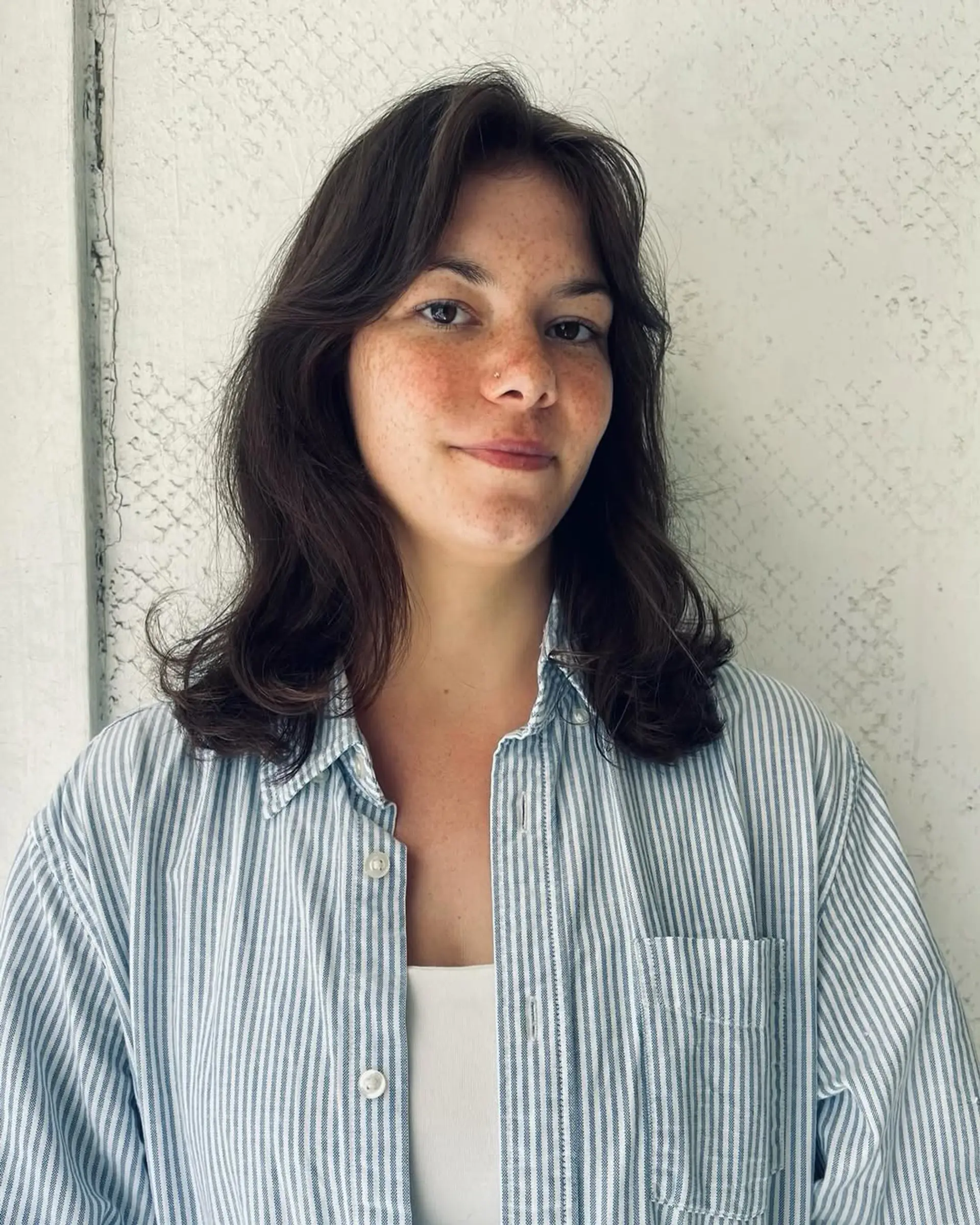 Medium-length wavy brown hair with soft layers, creating a natural, casual style. 2