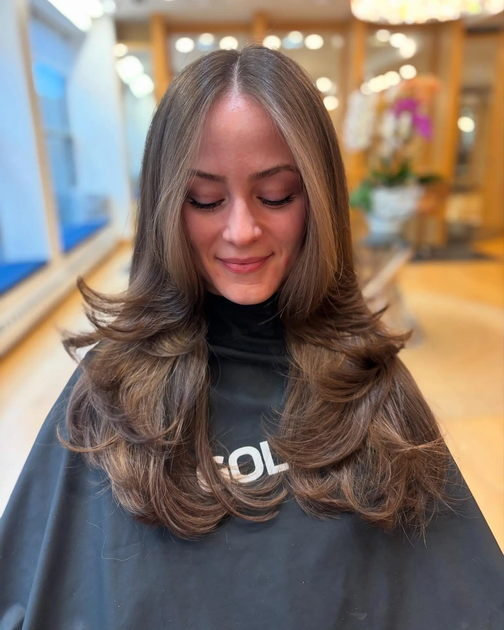 A long, layered haircut with face-framing layers and a bouncy blowout. 1