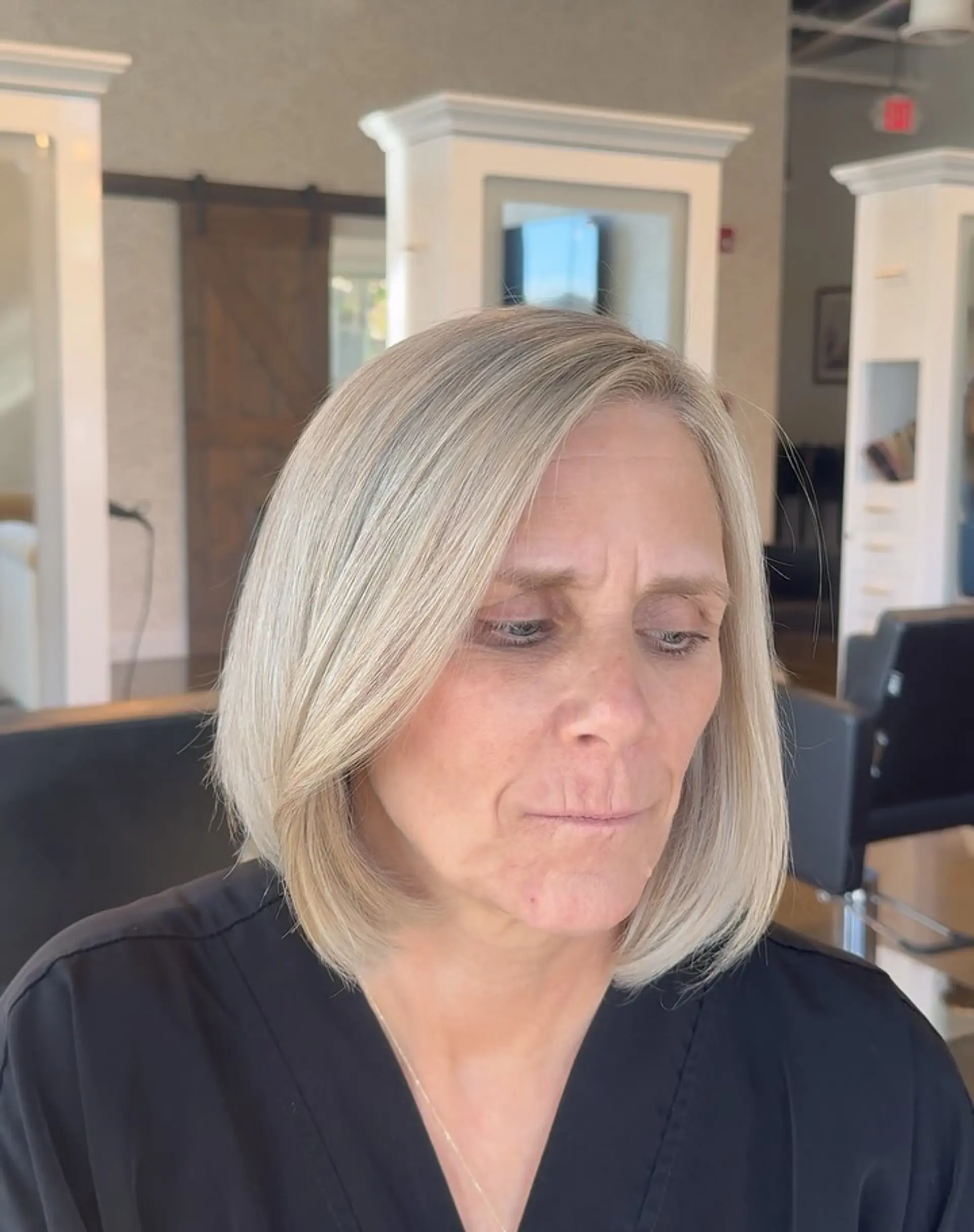 A sleek, side-parted ash blonde bob with smoothly curved ends resting just above the shoulders. 1