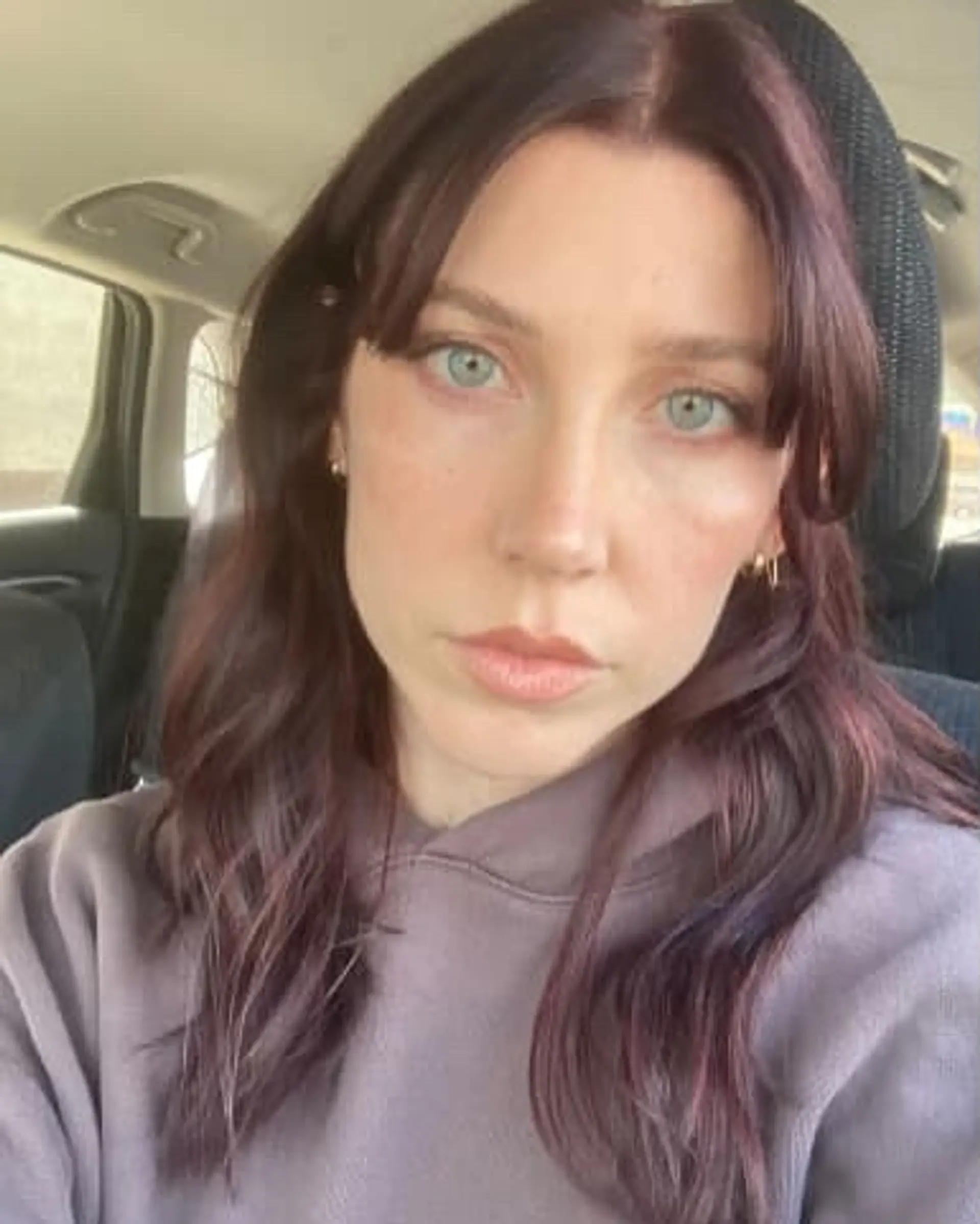 A wavy medium-length hairstyle with face-framing layers and Bardot bangs. 1