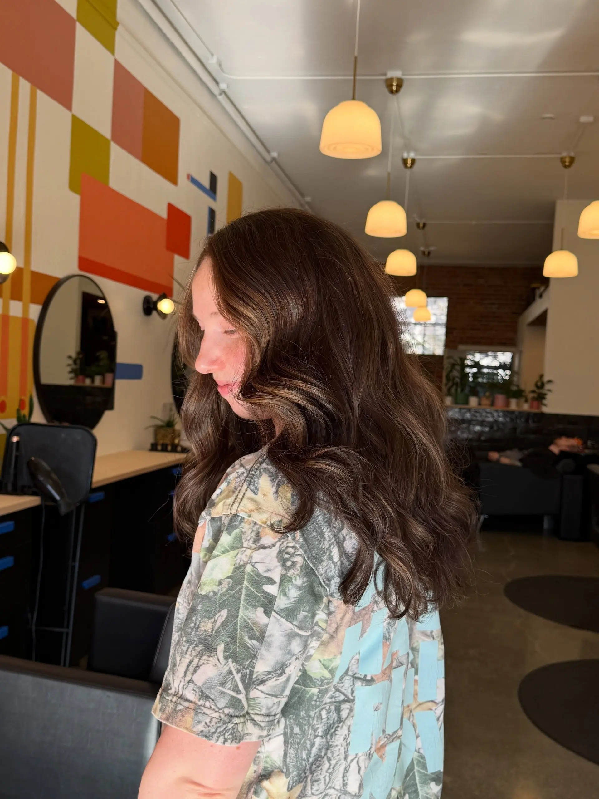 Long brunette hair styled in polished, flowing waves with soft dimensional highlights. 1