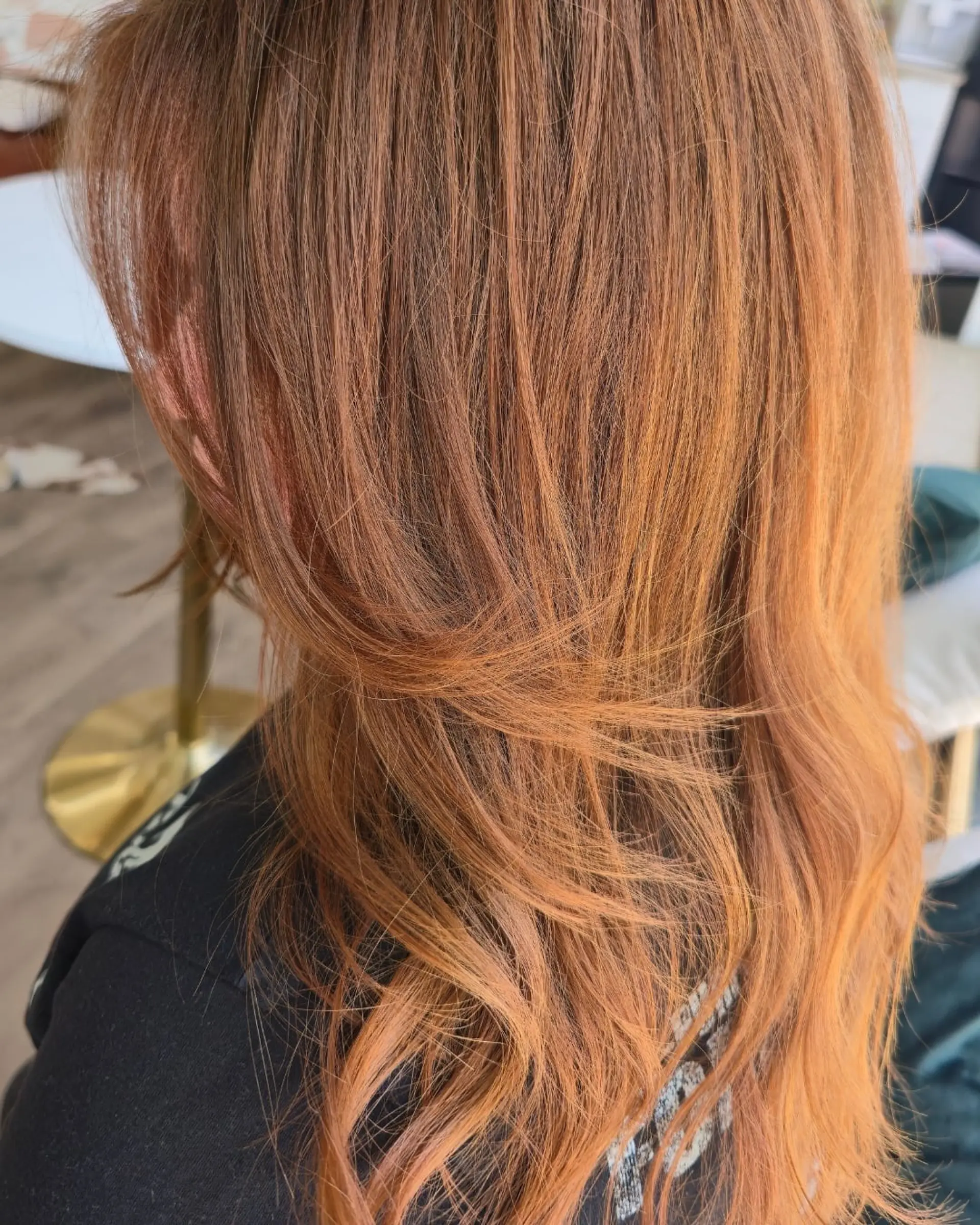 Warm autumn copper shade cut with soft, textured layers and gentle wavy ends. 1