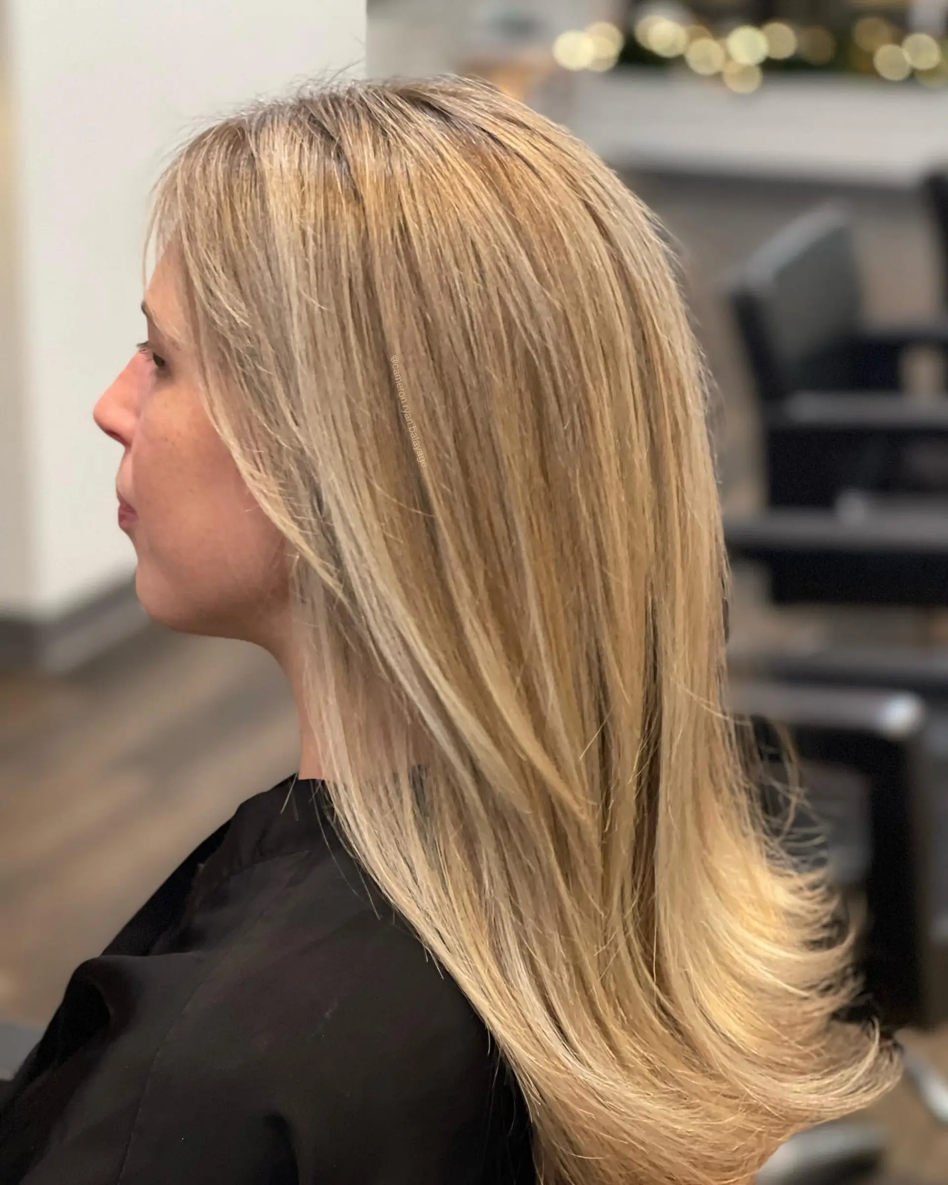 Long, layered straight hair with gently flicked ends, colored with finely woven dimensional blonde highlights. 1