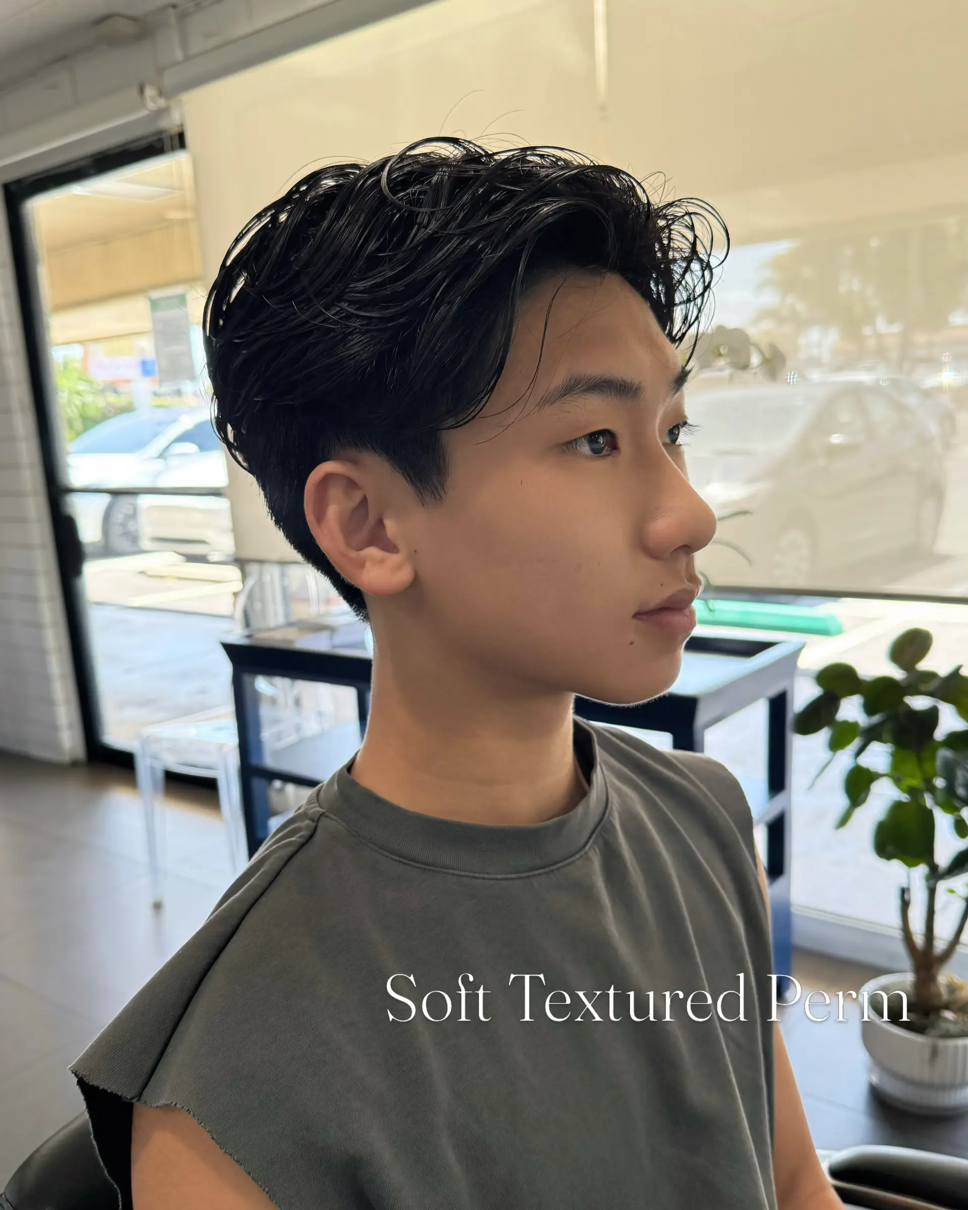 A soft textured perm on short dark hair featuring natural waves, gentle flow, and clean tapered sides. 1