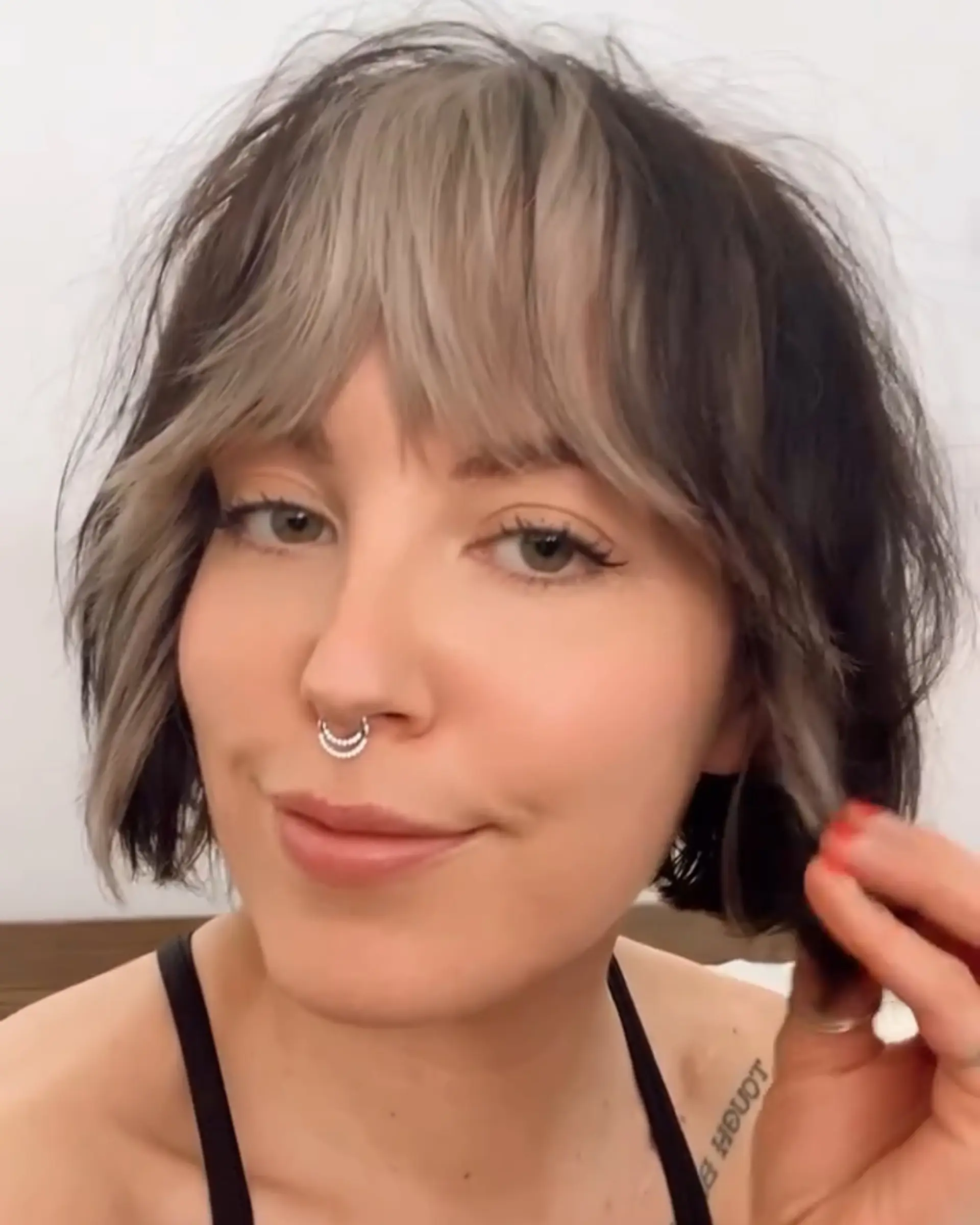 A textured chin-length bob featuring contrast ash blonde bangs and face-framing pieces against a dark brown base. 1