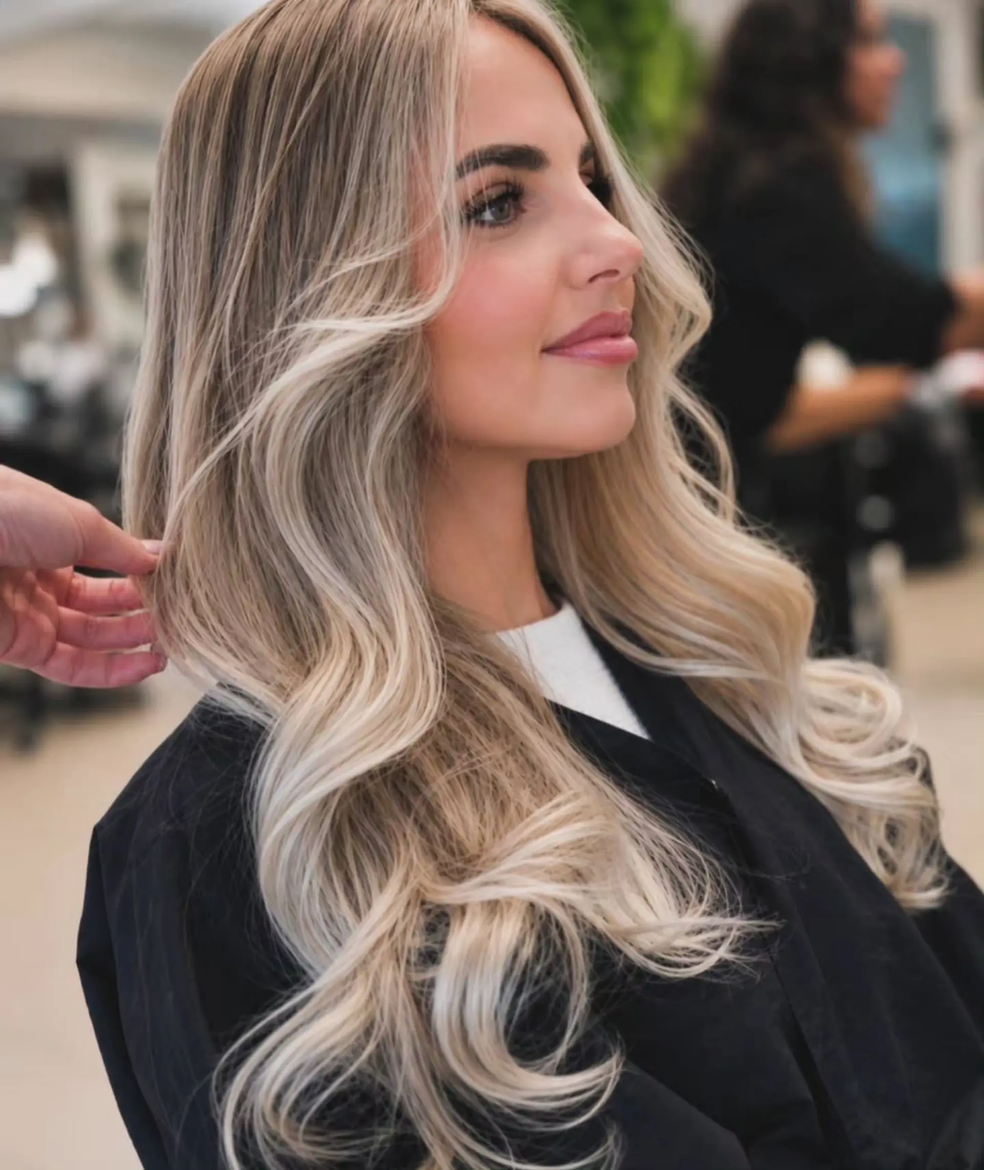 Long dimensional blonde hair styled in soft loose waves with bright face-framing highlights. 1