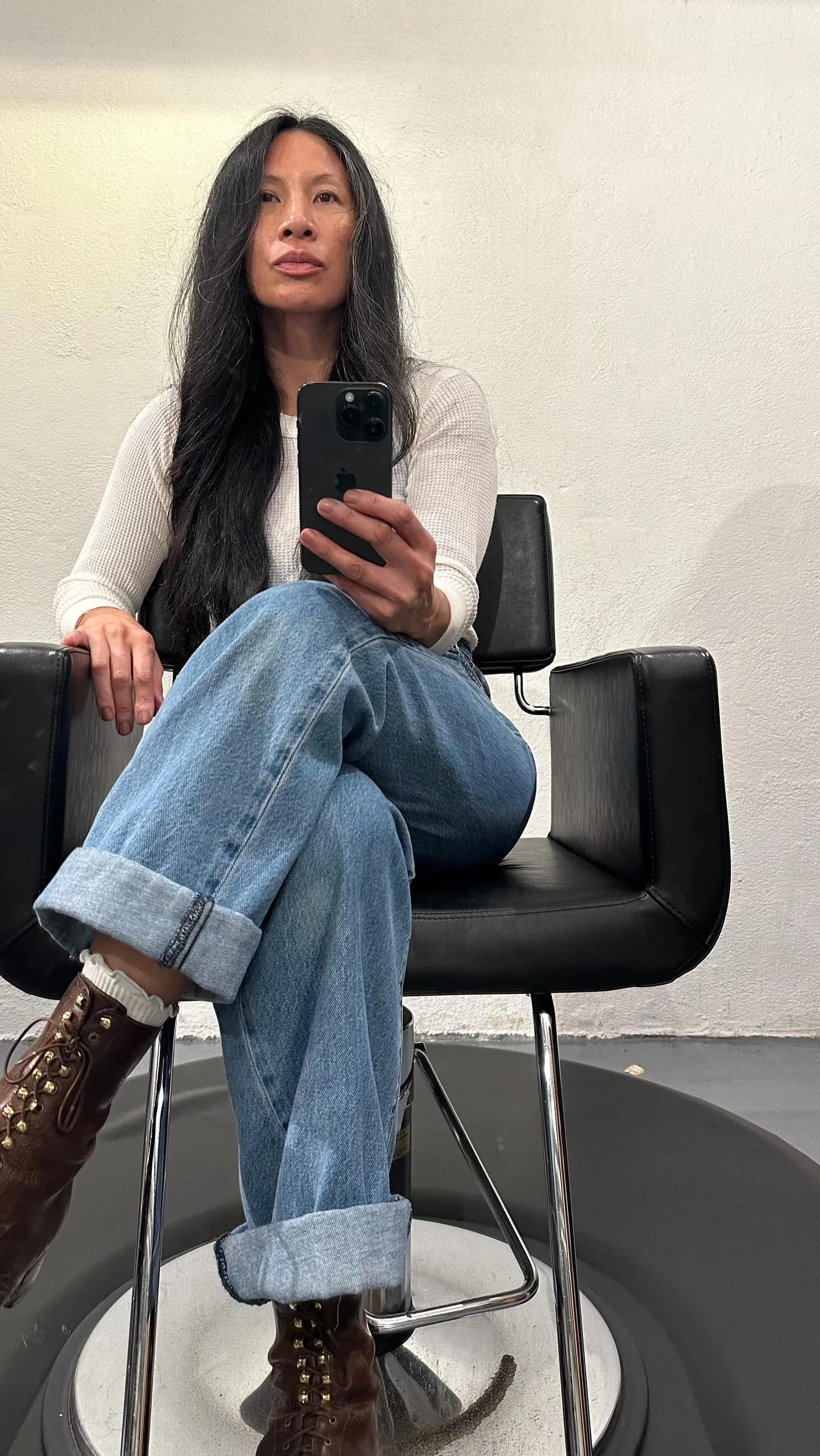 Long, dark hair styled with a straight paddle brush blowout, featuring natural grey streaks. 1