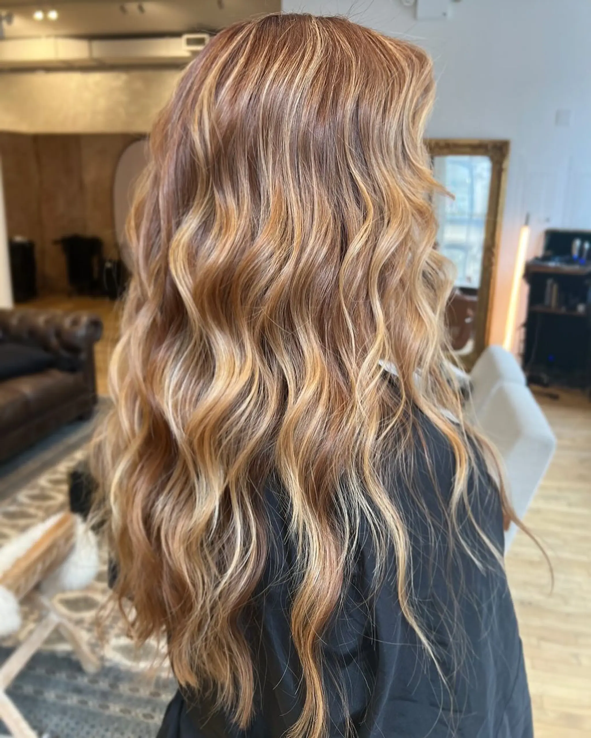 Long, wavy hair with a balayage blend of copper, blonde, and bronze hues. The style has loose, voluminous waves with layered texture for a natural, sun-kissed look.

Stylist: @danieldoeshair