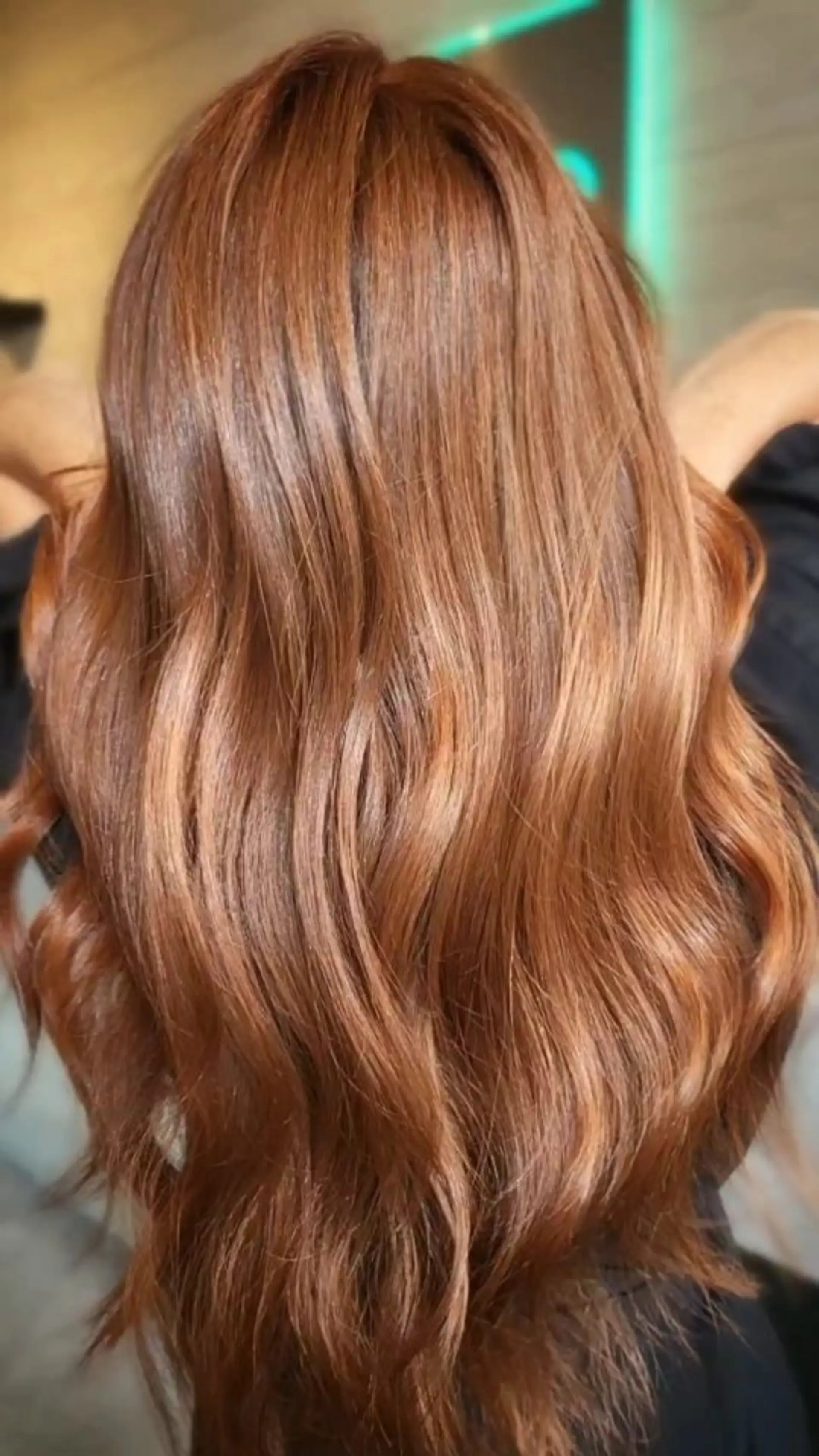 Long, vibrant copper hair styled into polished, soft waves with a dimensional glossy shine. 1