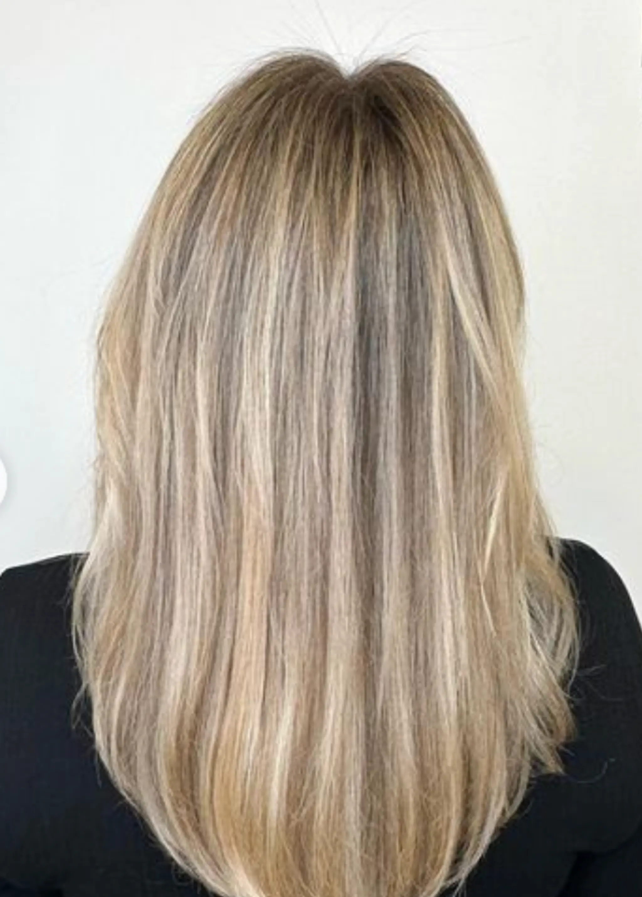 Medium-length, straight, layered hair with feathered ends, face-framing strands, and a subtle side part. The blonde color is interspersed with light brown hues, giving the hair a natural shine.

Color by @simabeautynyc
 2