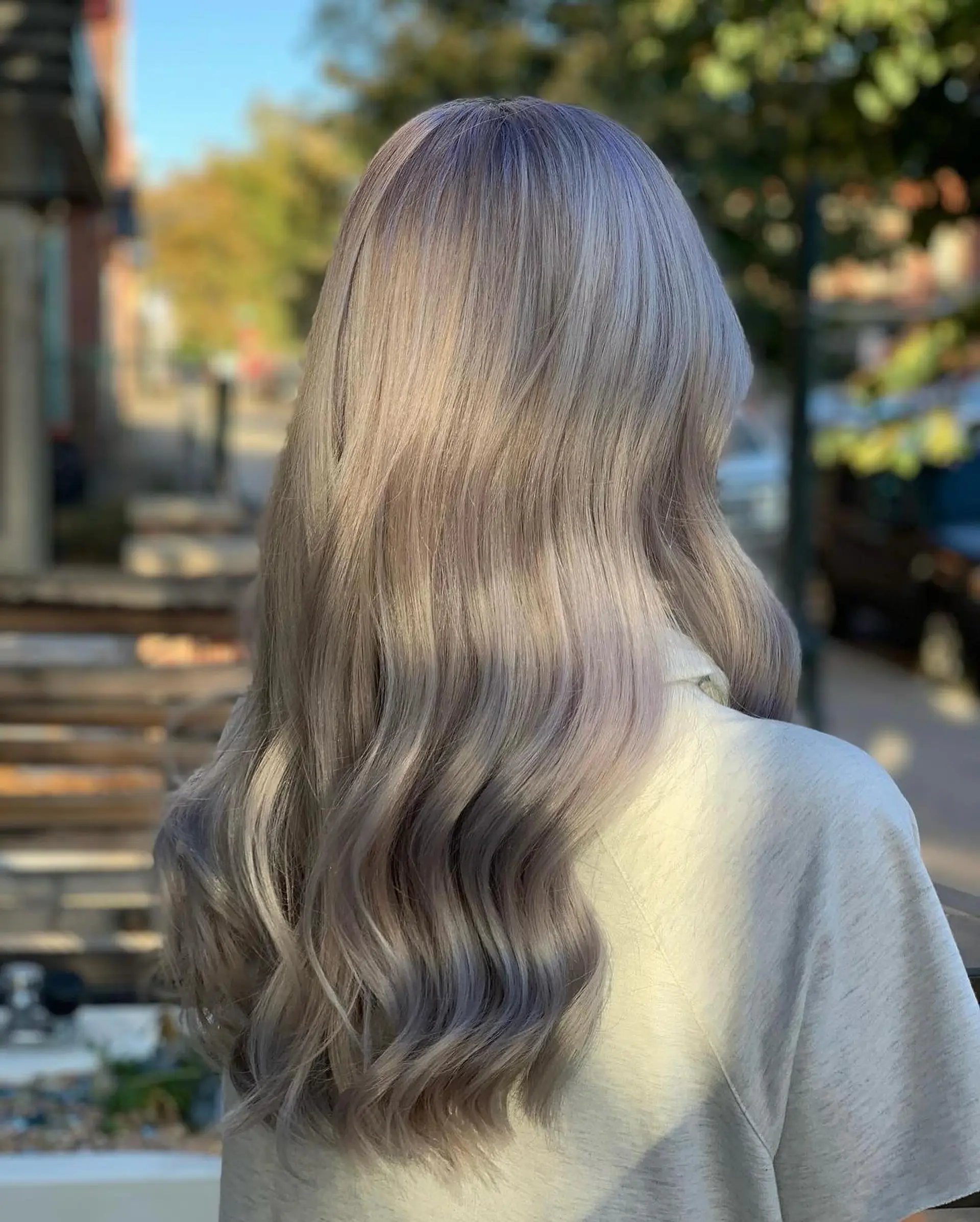 Long silvery ash blonde hair styled in smooth, flowing waves. 1