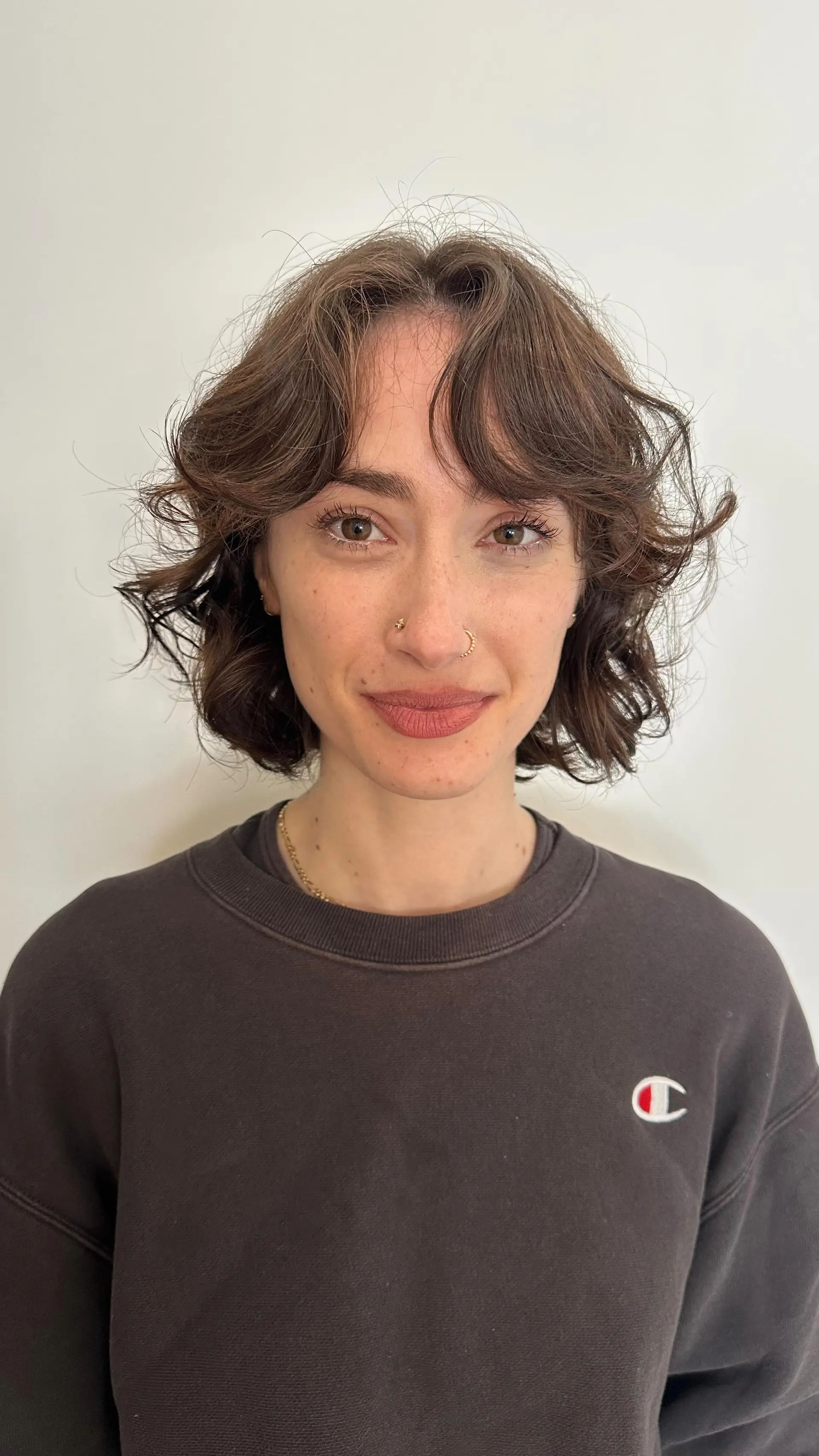 A textured chin-length wavy bob featuring soft curtain bangs and layered movement. 1