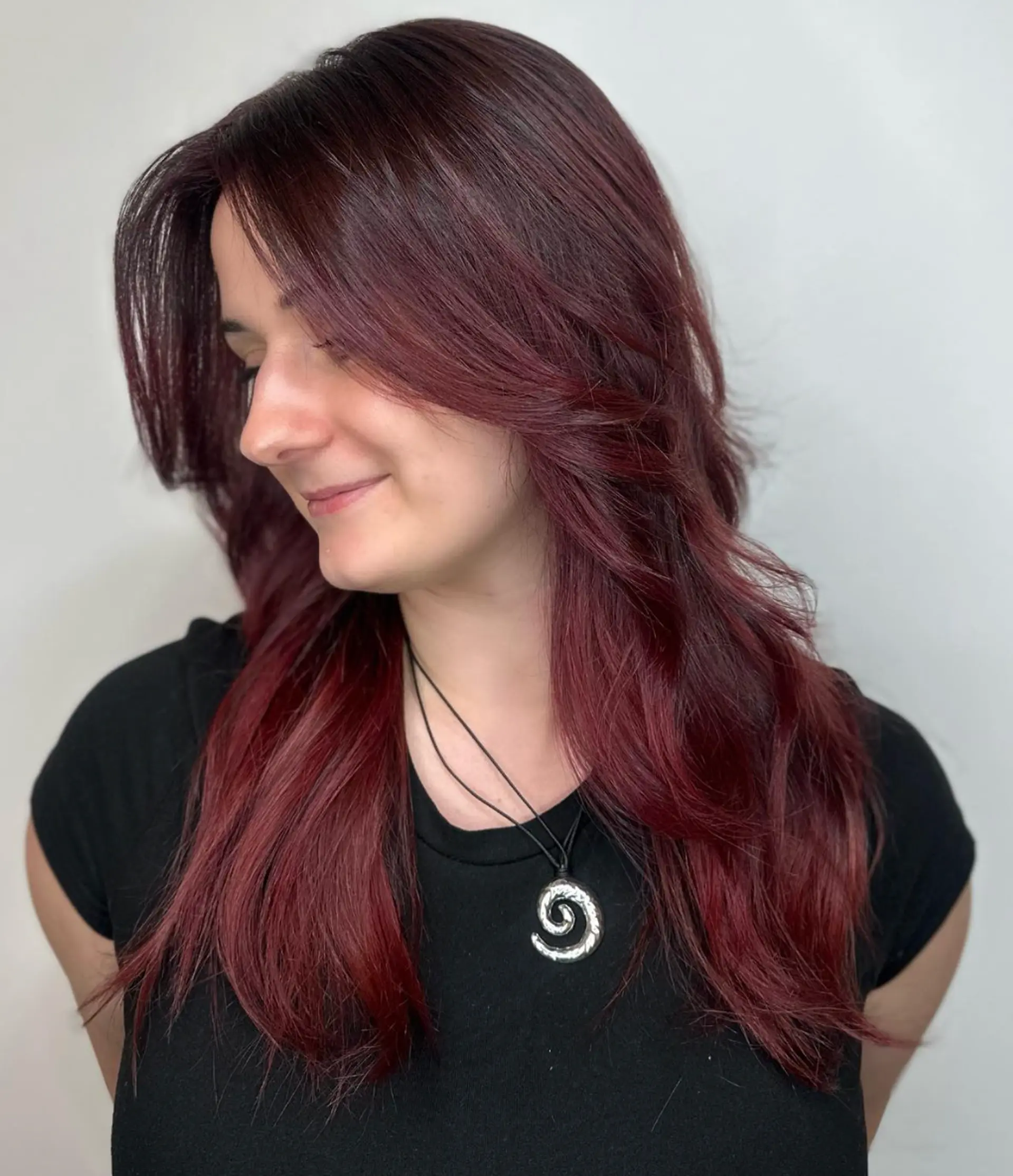 Long, wavy hair in a rich burgundy color with layers, side-swept bangs, and gentle waves.

Color by @simabeautynyc

 1