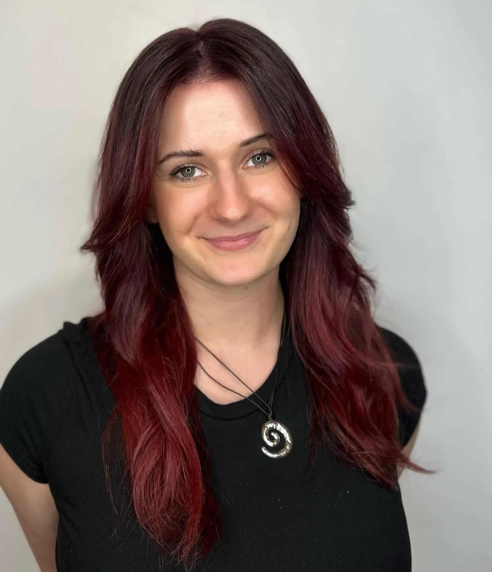 Long, wavy hair in a rich burgundy color with layers, side-swept bangs, and gentle waves.

Color by @simabeautynyc

 2