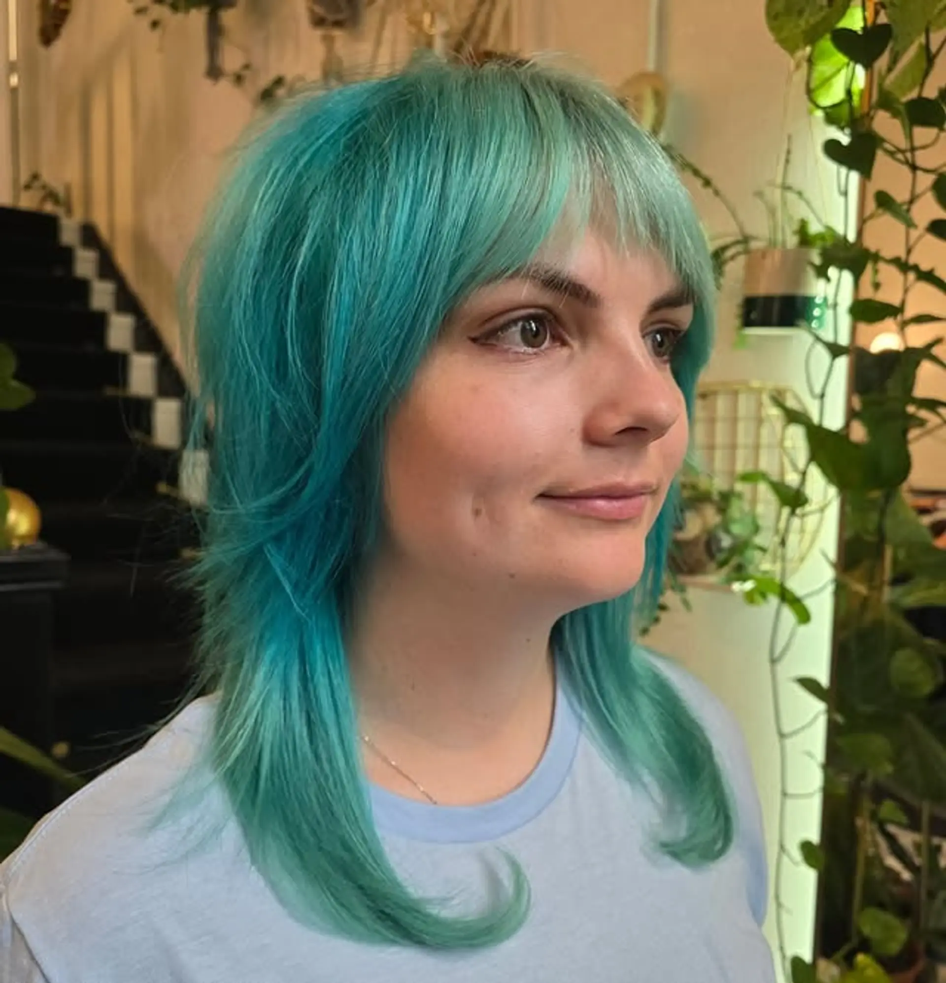 A medium-length shag haircut with layered ends and full bangs. 1