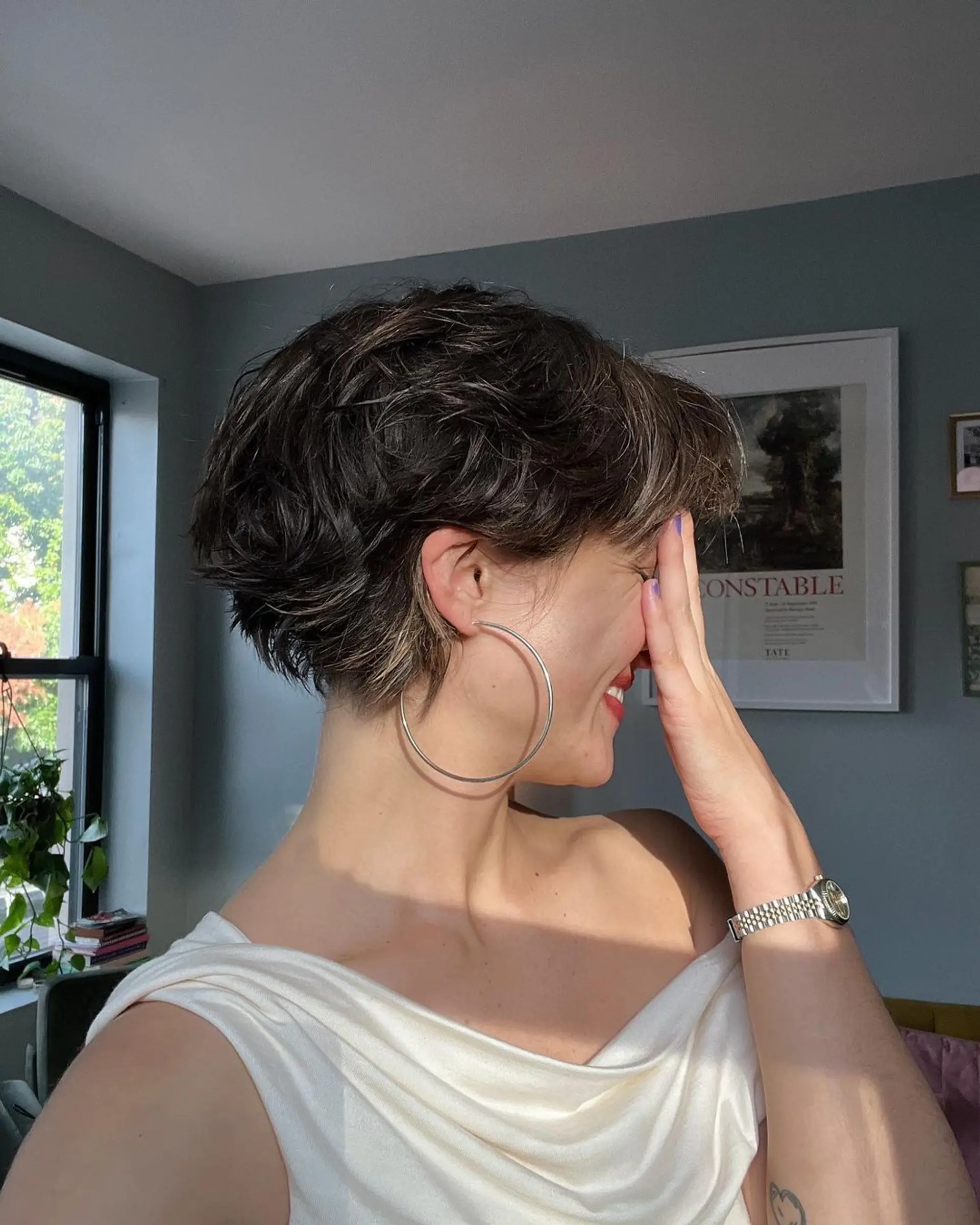 A short, wavy cut with textured layers and subtle highlights, featuring a face-framing fringe for a casual, chic style. 2