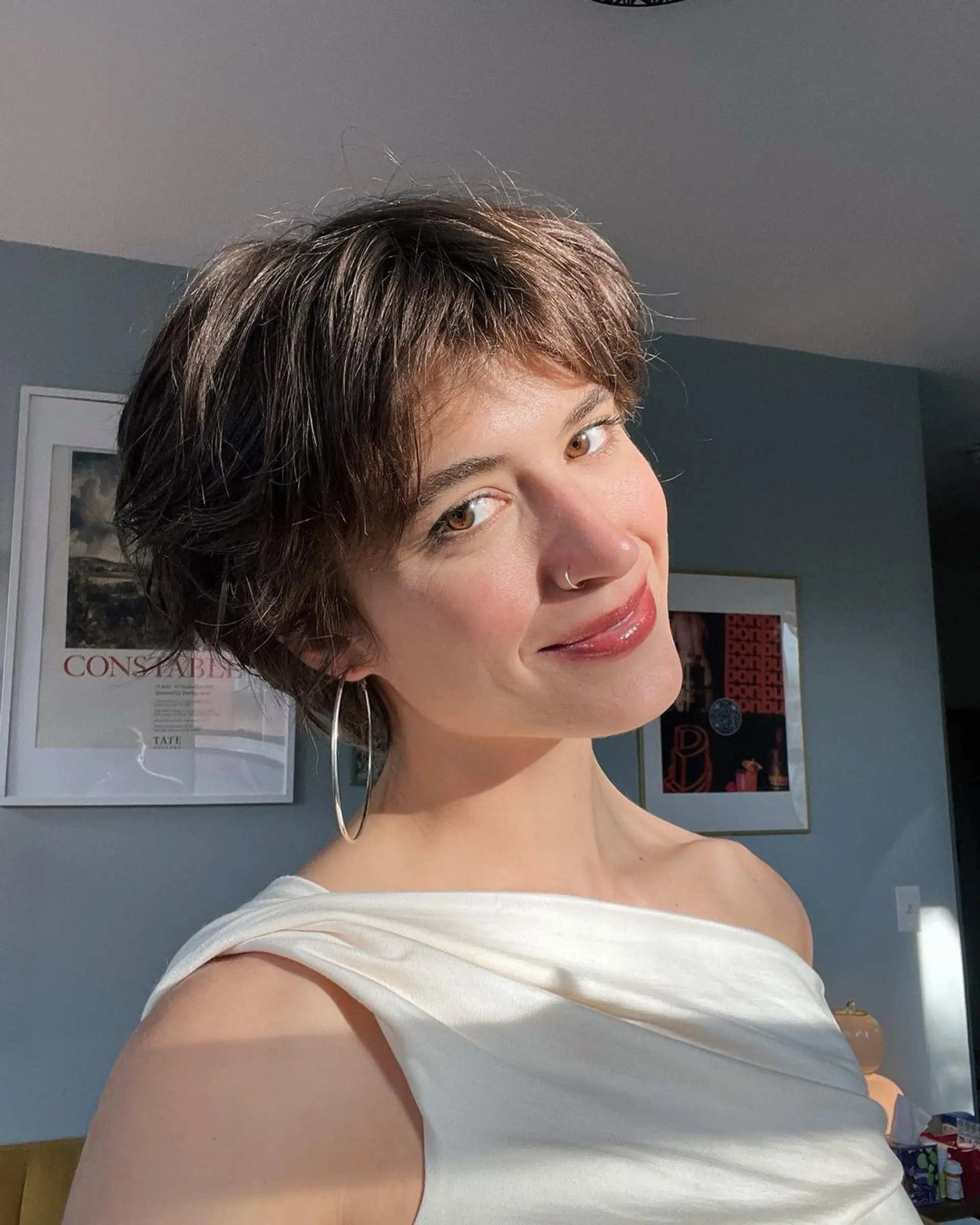 A short, wavy cut with textured layers and subtle highlights, featuring a face-framing fringe for a casual, chic style. 1