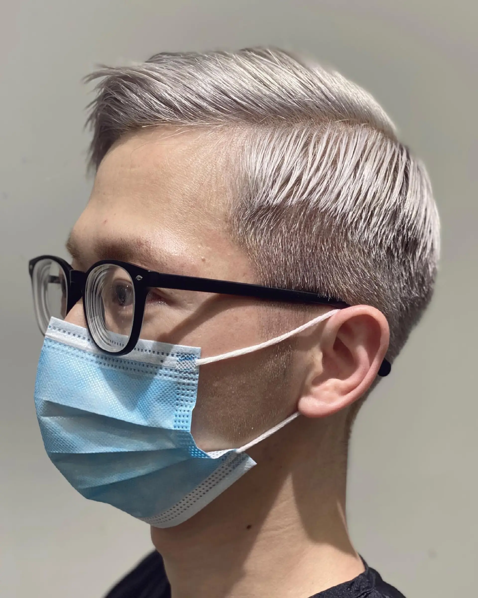 A short, textured buzz cut, bleached to a striking platinum blonde/silver. 2