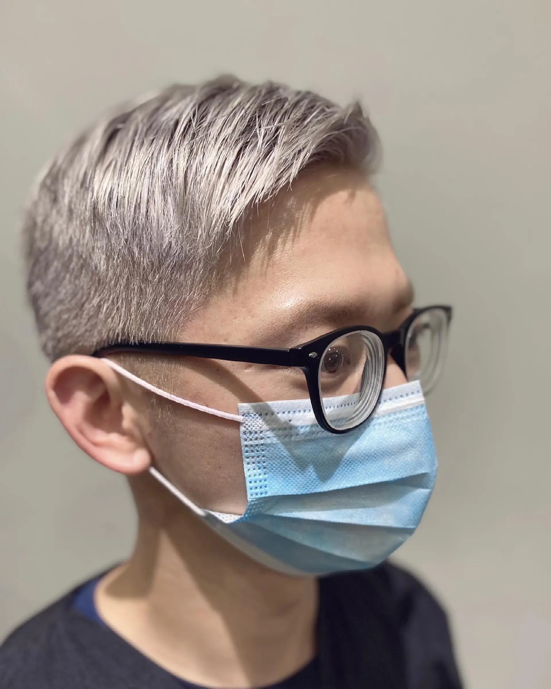 A short, textured buzz cut, bleached to a striking platinum blonde/silver. 4