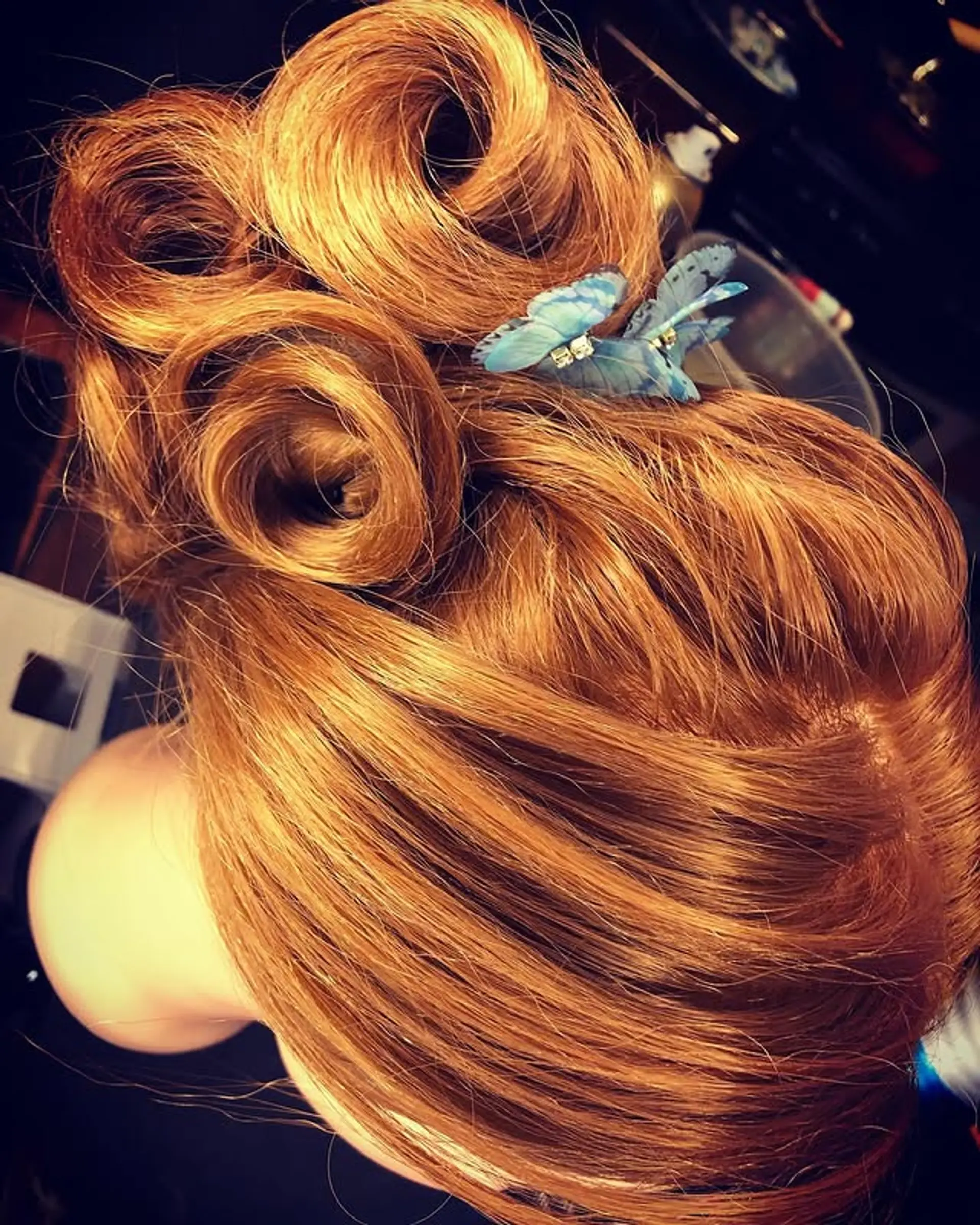 A vintage updo featuring rolled curls pinned up for an elegant look. 1