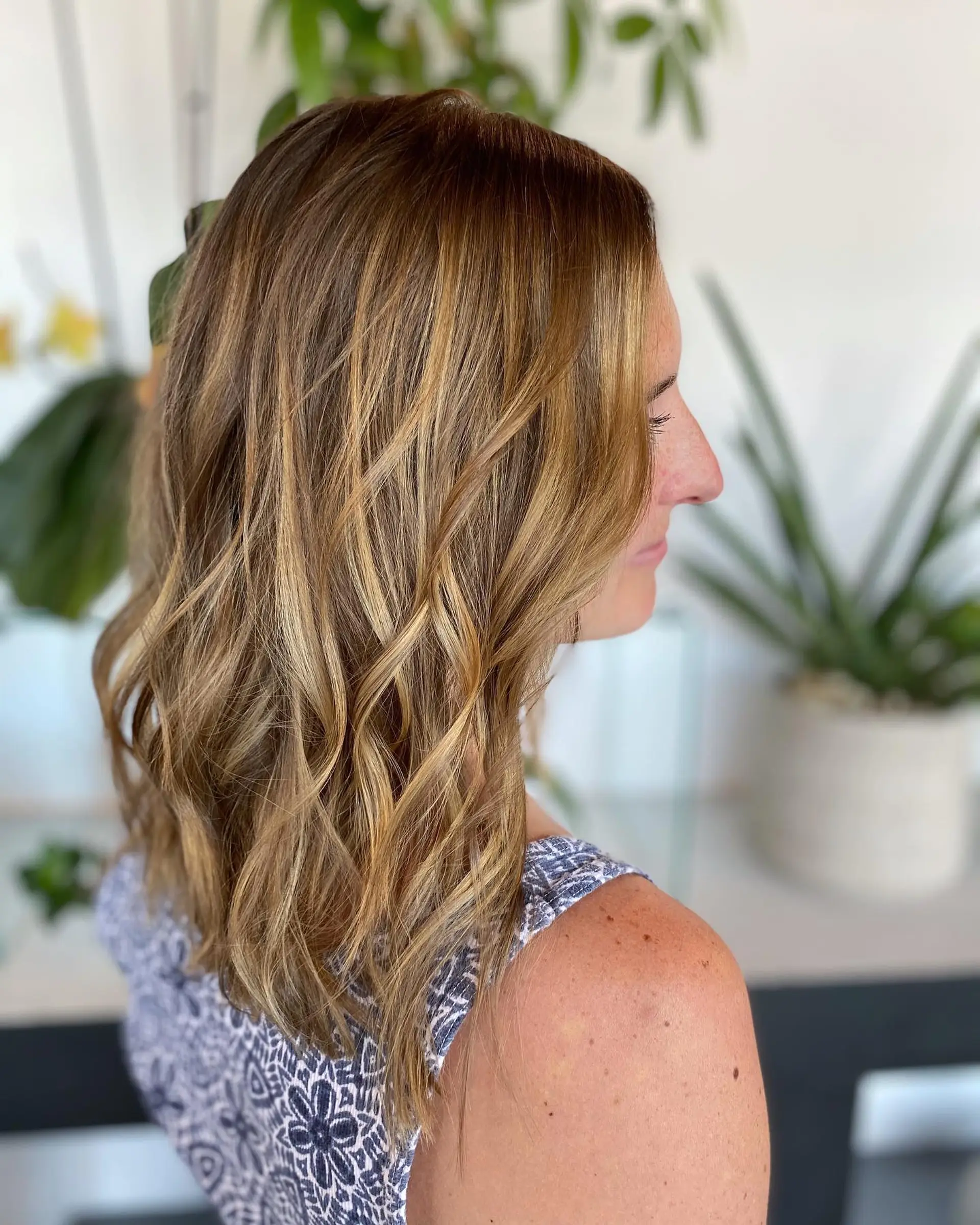Medium-length honey blonde balayage with warm dimension, cut with light layers and styled in soft textured waves. 1
