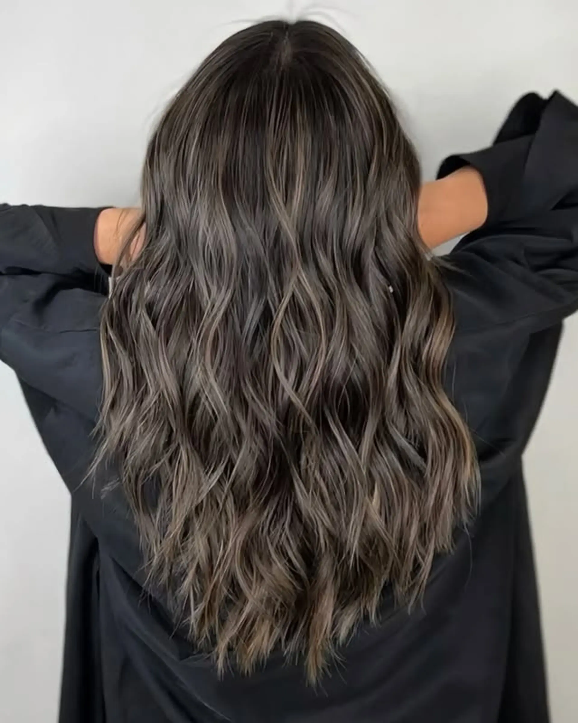 Long, wavy hairstyle with an ash brown balayage that transitions into a subtle ombre. 1