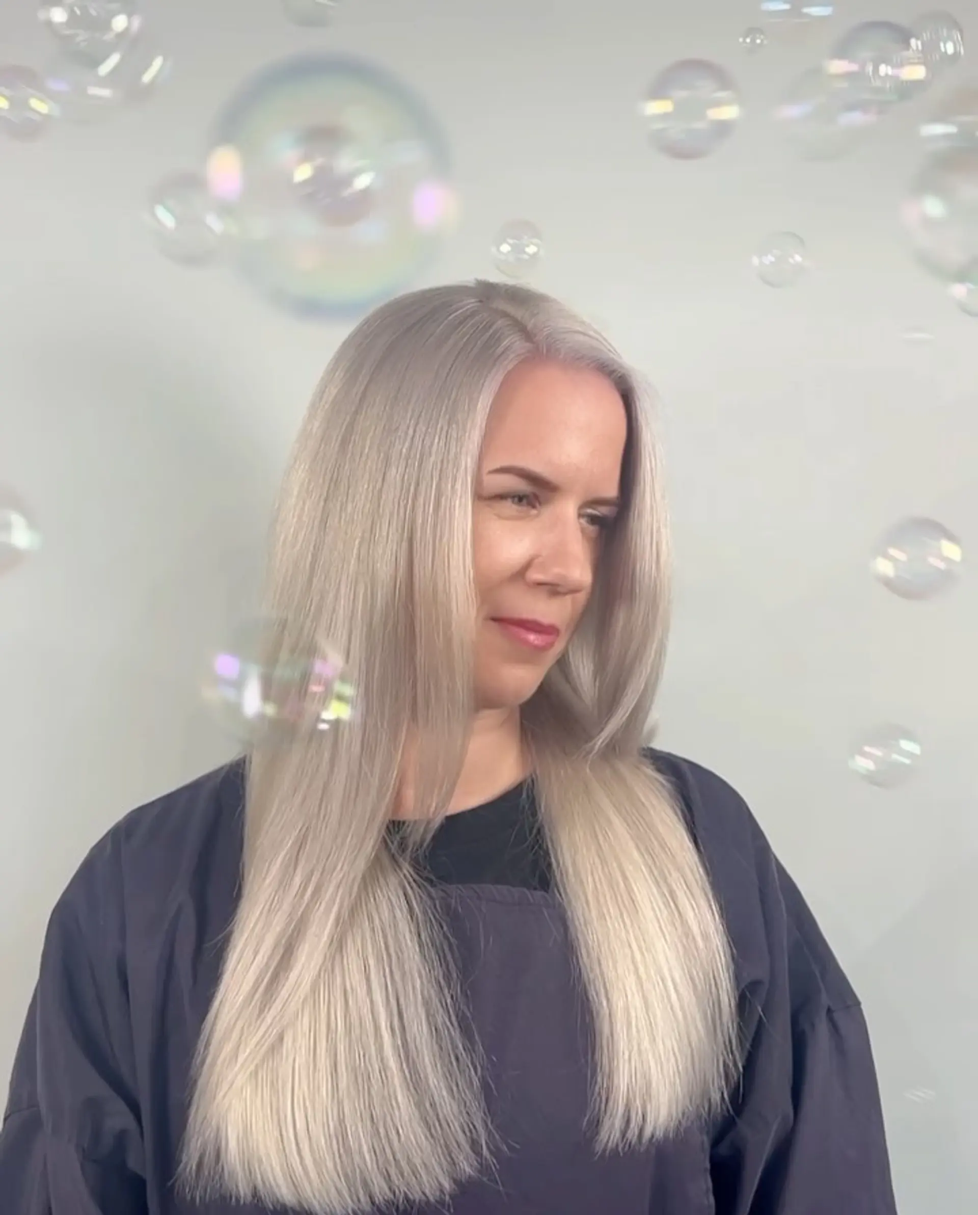 Sleek, straight platinum blonde hair with a polished blowout finish. 1