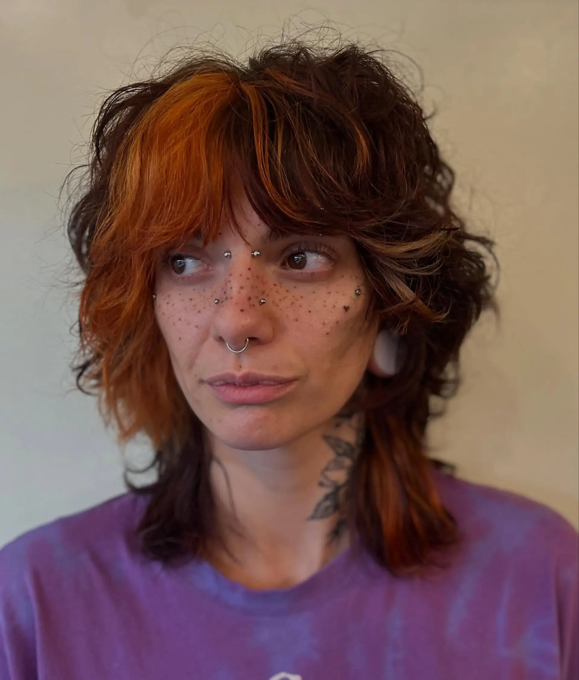 A textured shag mullet in dark brown featuring a high-contrast bright orange color block along the front bangs and temple. 1