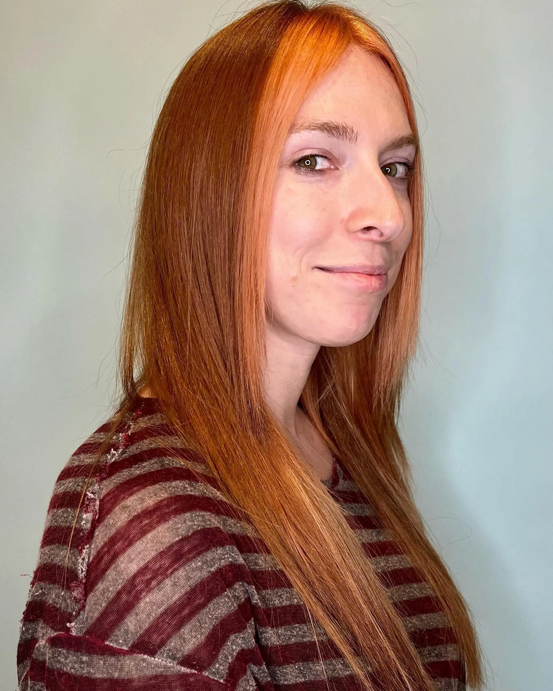 Long, straight hair with copper-red color and face-framing ginger money piece highlights. 1