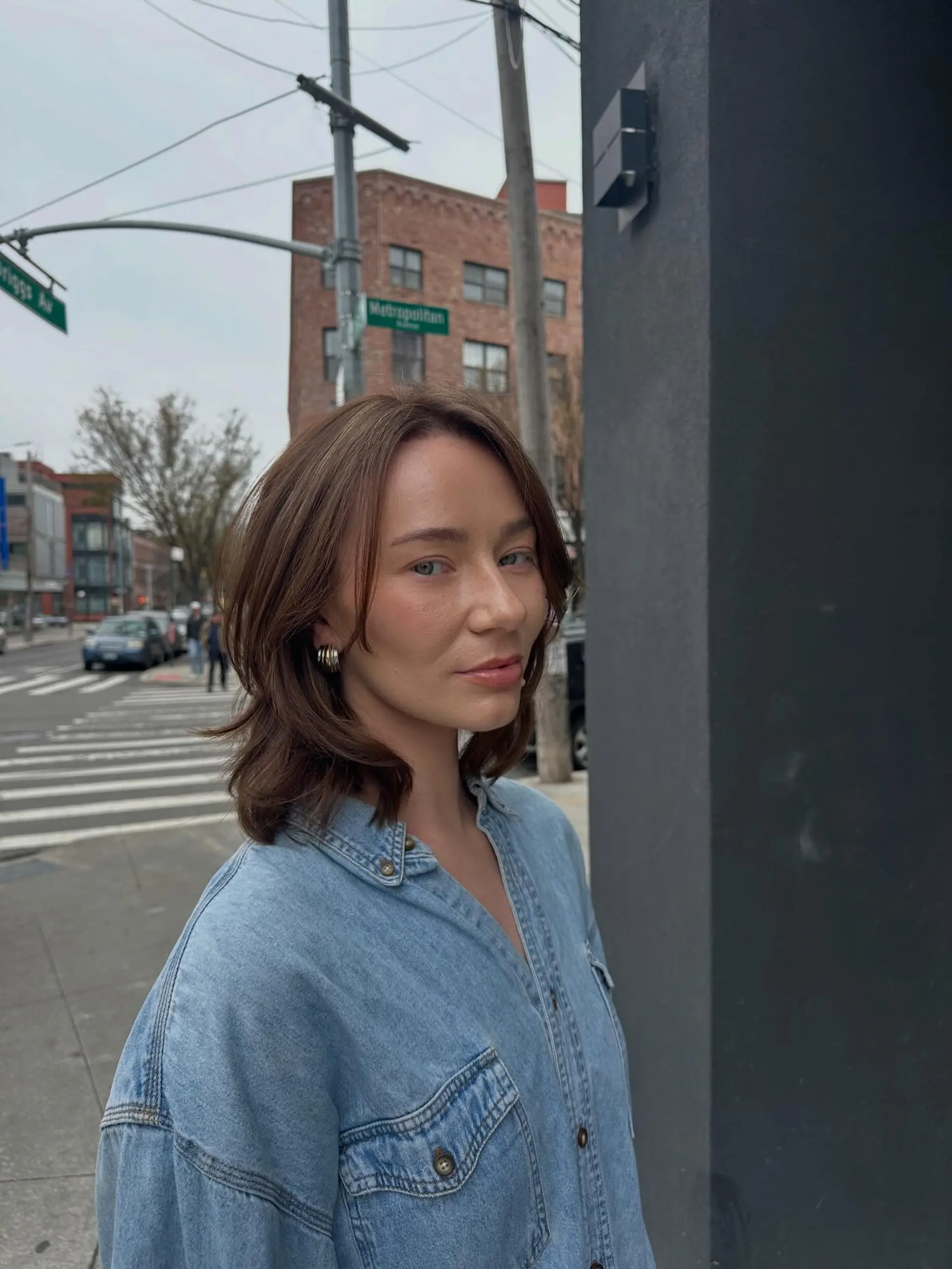 A medium brown shoulder-length bob styled with soft, face-framing layers and a natural texture. 1