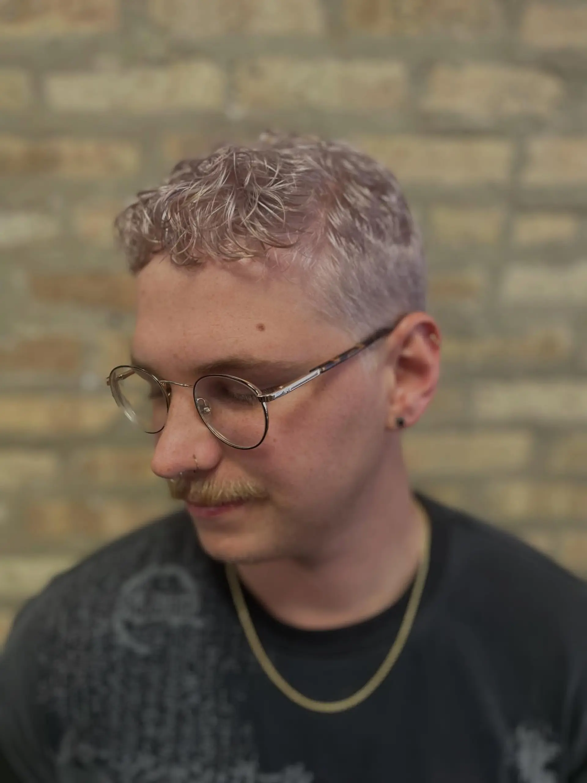 A short, wavy crop cut bleached and toned to a luminous cool-toned violet platinum blonde. 1