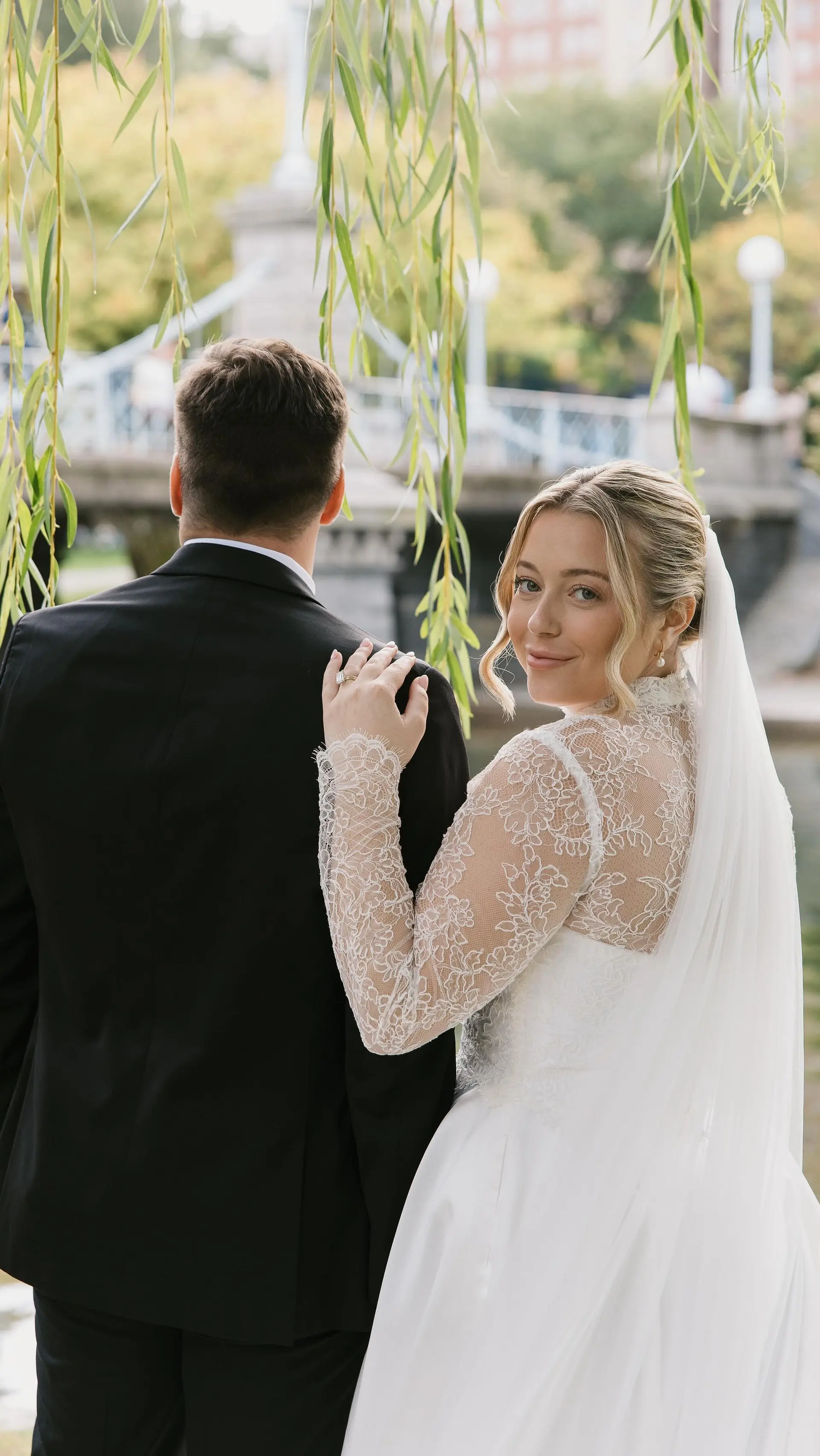 A soft, romantic bridal updo paired with delicate face-framing waves and an elegant veil. 1