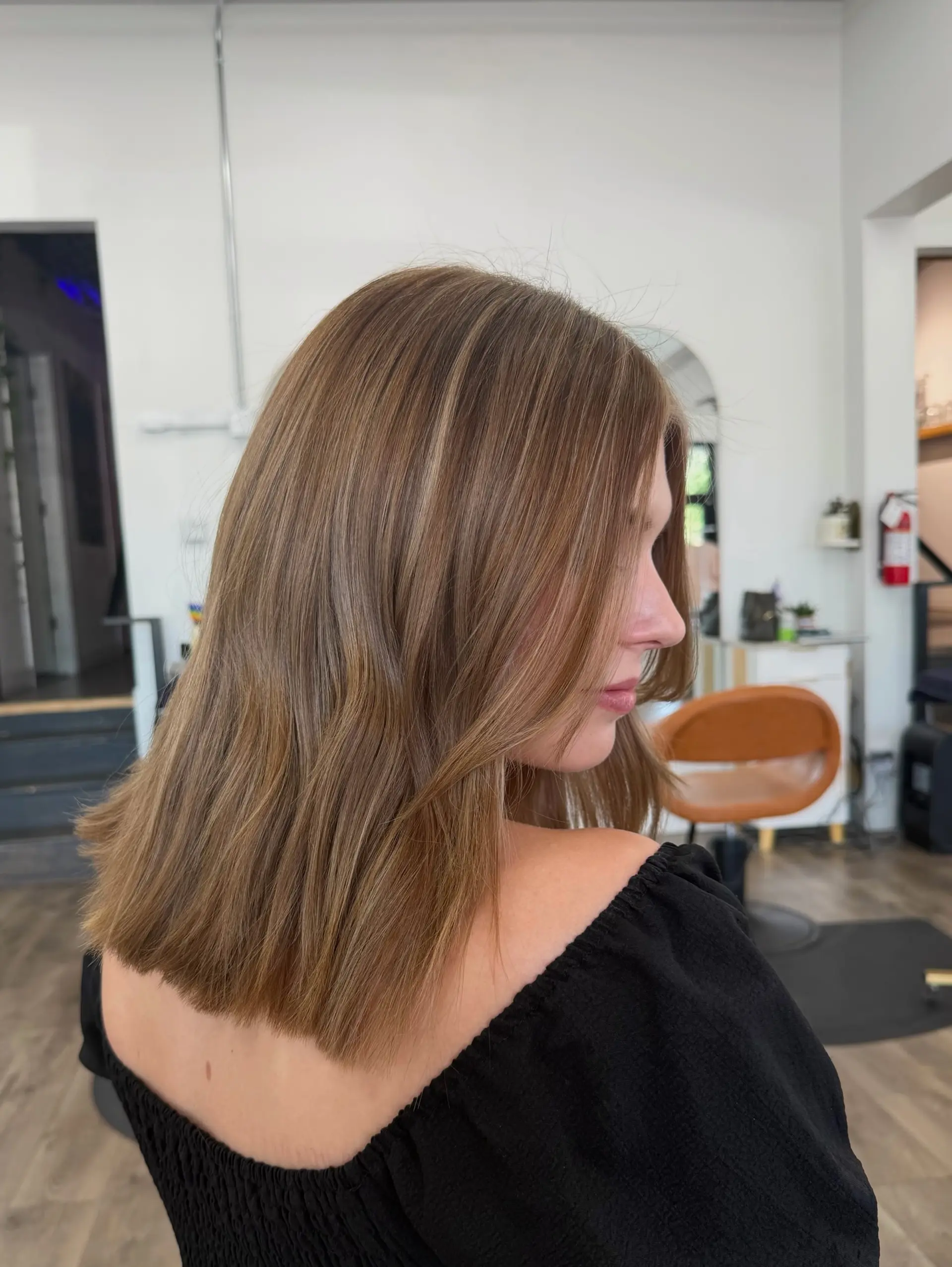 A sleek, blunt-cut lob featuring warm honey and caramel highlights with subtle face-framing layers. 1