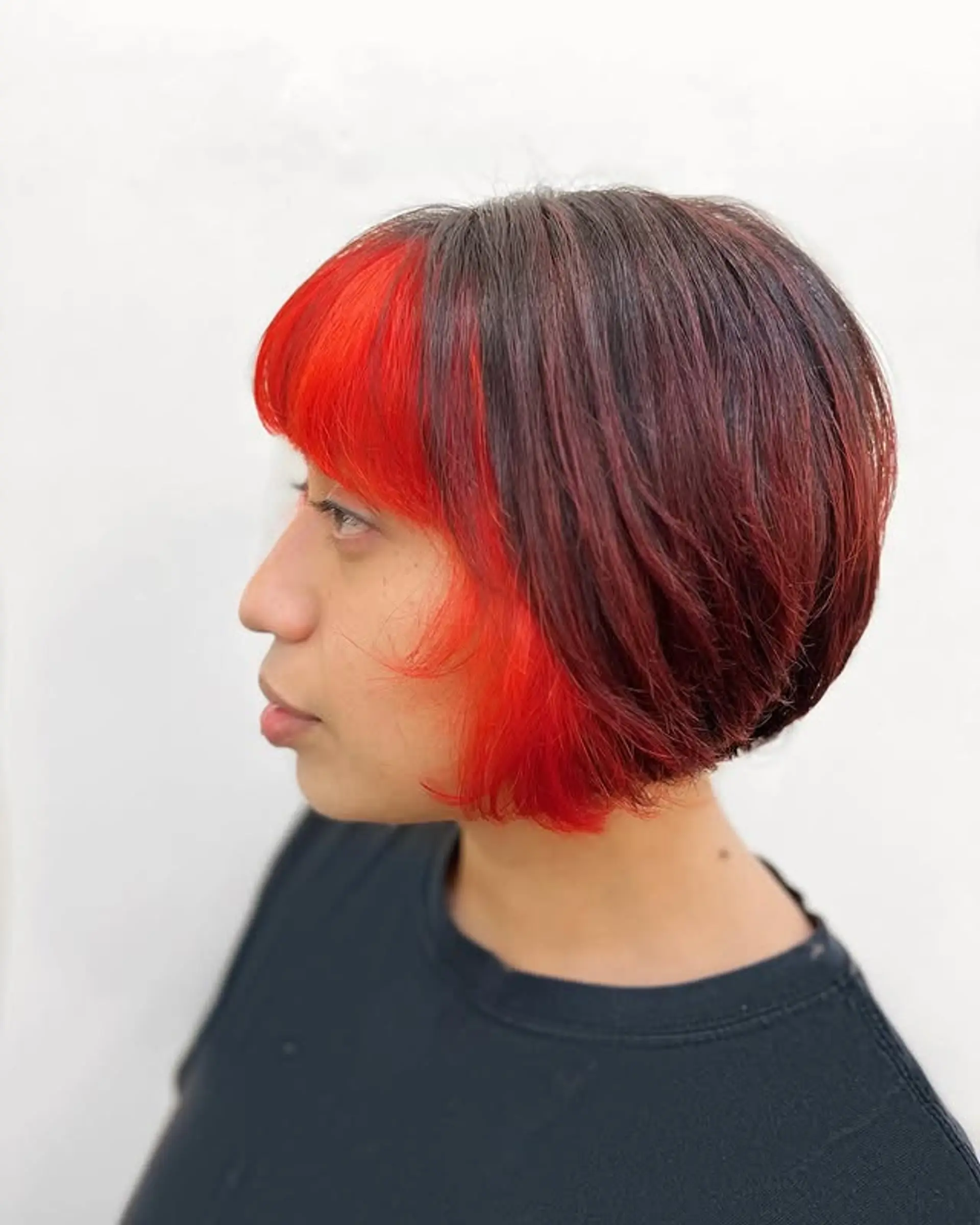 A short, layered bob with a vibrant color accent. 1