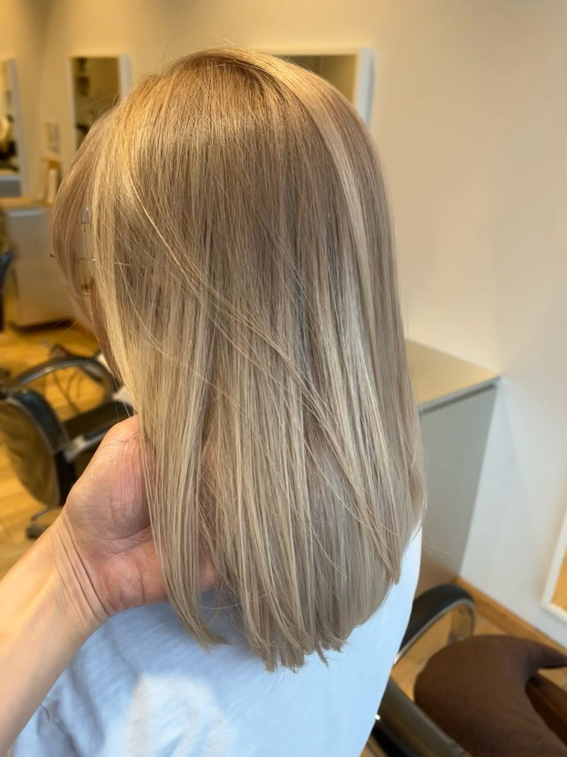 A straight medium-length style colored in a soft, cool ash beige blonde. 1