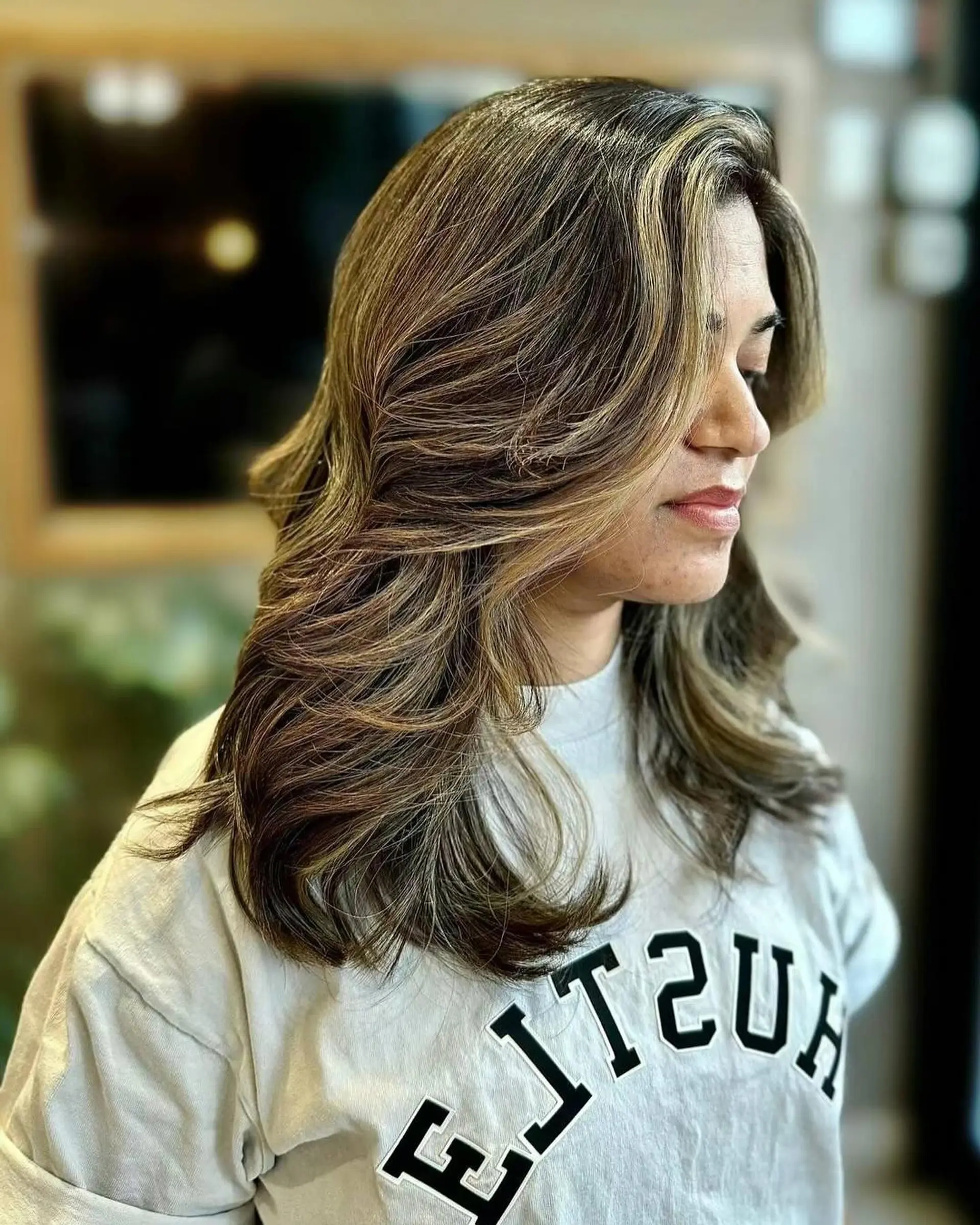 A medium-length wavy hairstyle with layers and bronde balayage. 1
